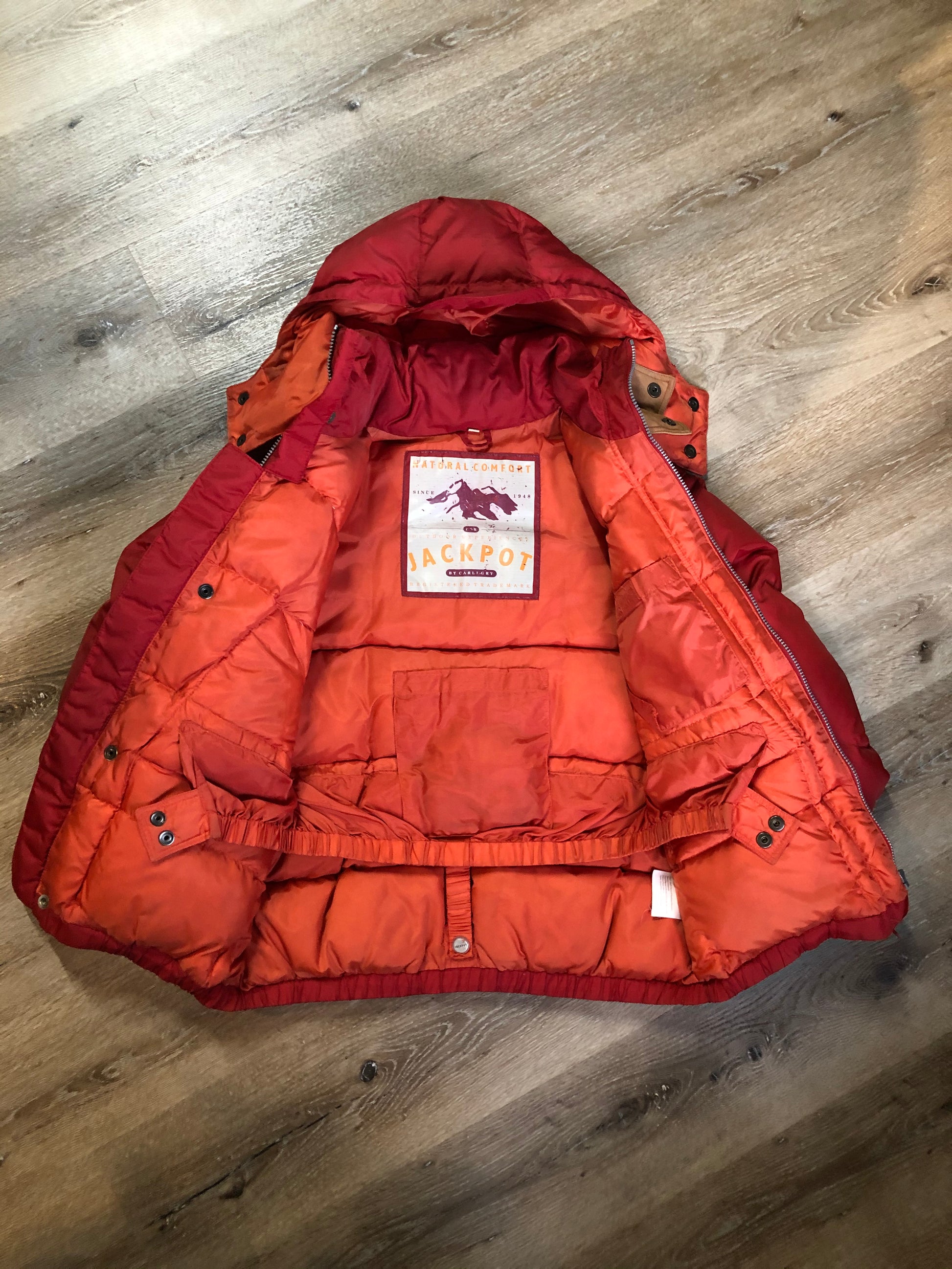 Kingspier Vintage - Vintage Jackpot by Carli Gry red down-fIlled puffer jacket with hood, zipper closure, flap pockets, zip pockets and three inside pockets large enough to fit an included small lightweight backpack,