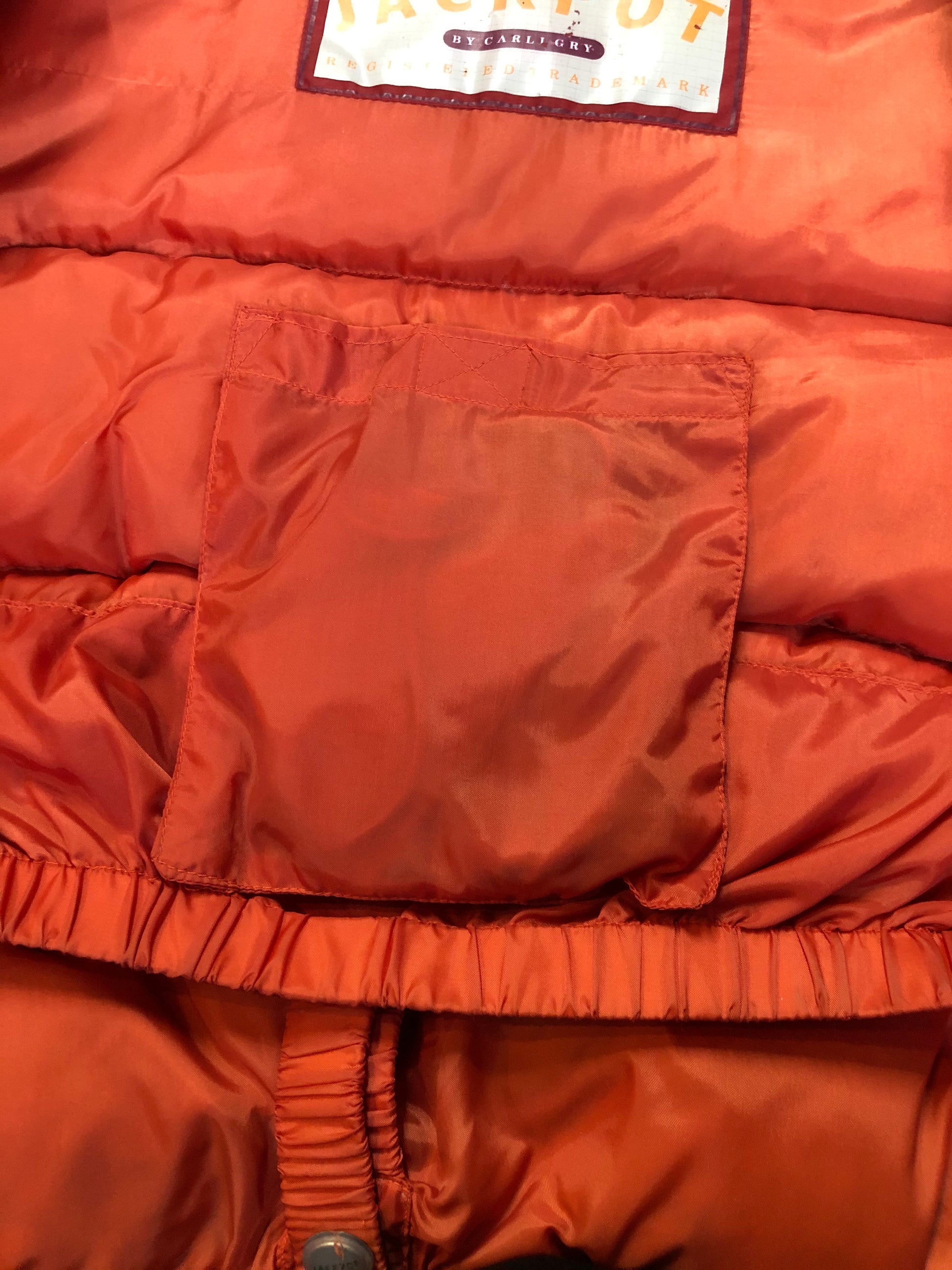 Kingspier Vintage - Vintage Jackpot by Carli Gry red down-fIlled puffer jacket with hood, zipper closure, flap pockets, zip pockets and three inside pockets large enough to fit an included small lightweight backpack,