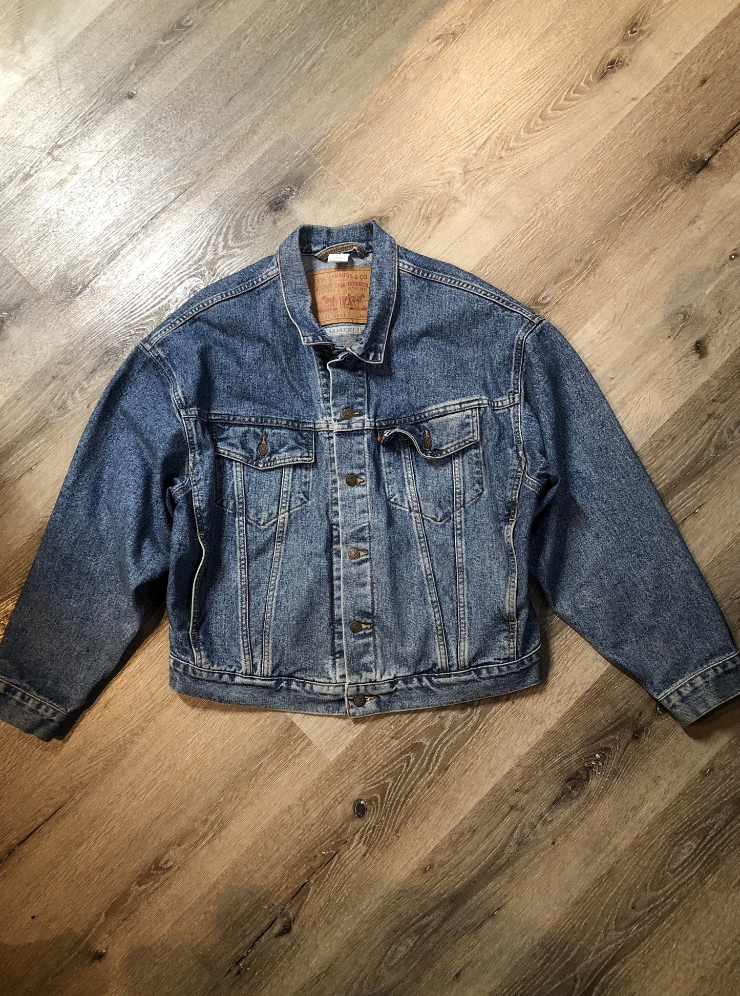 Vintage 1980’s Levi’s medium wash denim trucker jacket with button closures, two flap pockets on the chest, two side pockets and two inside pockets. Red Tab, 100% cotton, size large -Kingspier Vintage