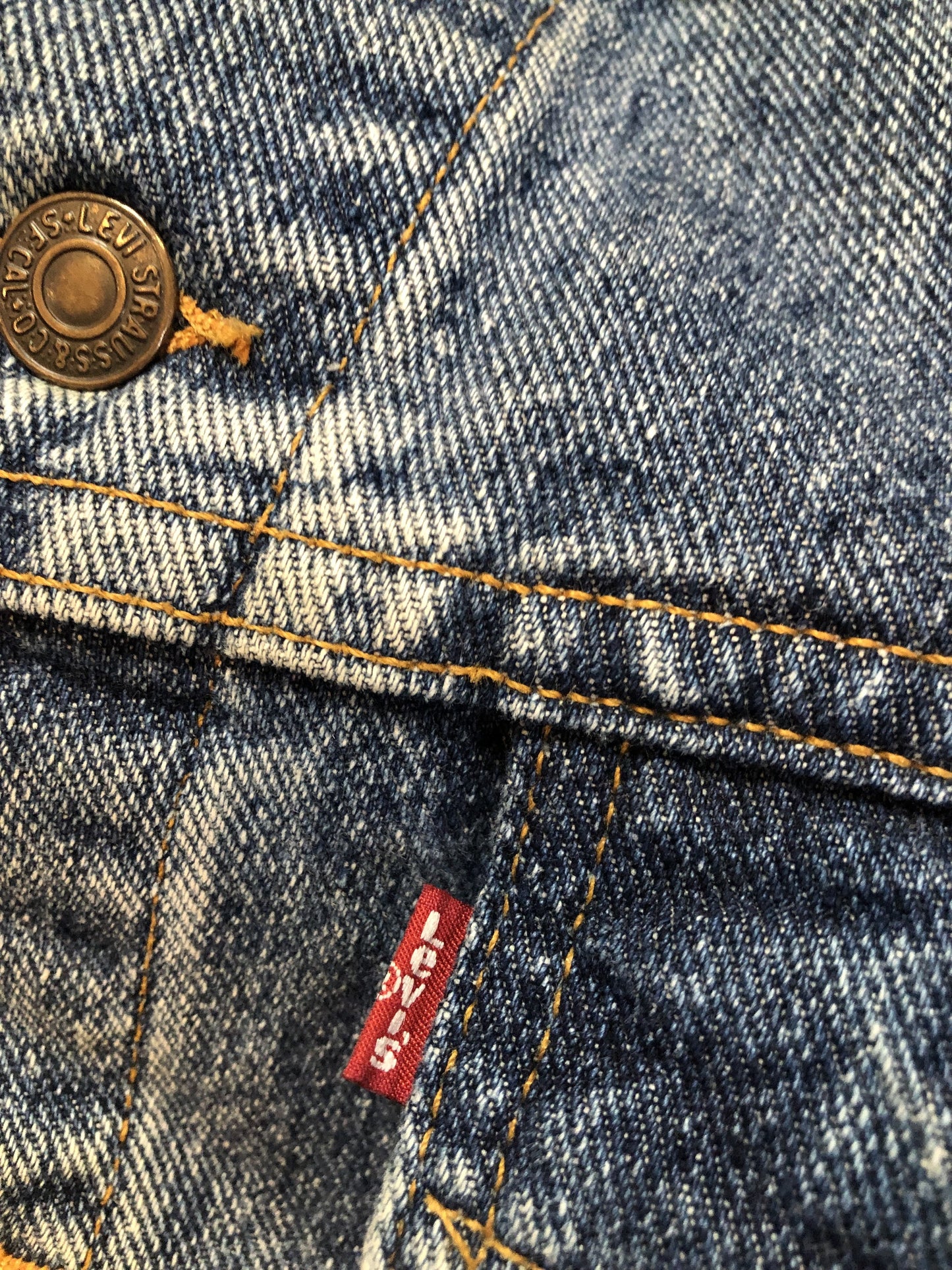 Vintage 1980’s Levi’s medium wash denim trucker jacket with button closures, two flap pockets on the chest, two side pockets and two inside pockets. Red Tab, 100% cotton, size large -Kingspier Vintage