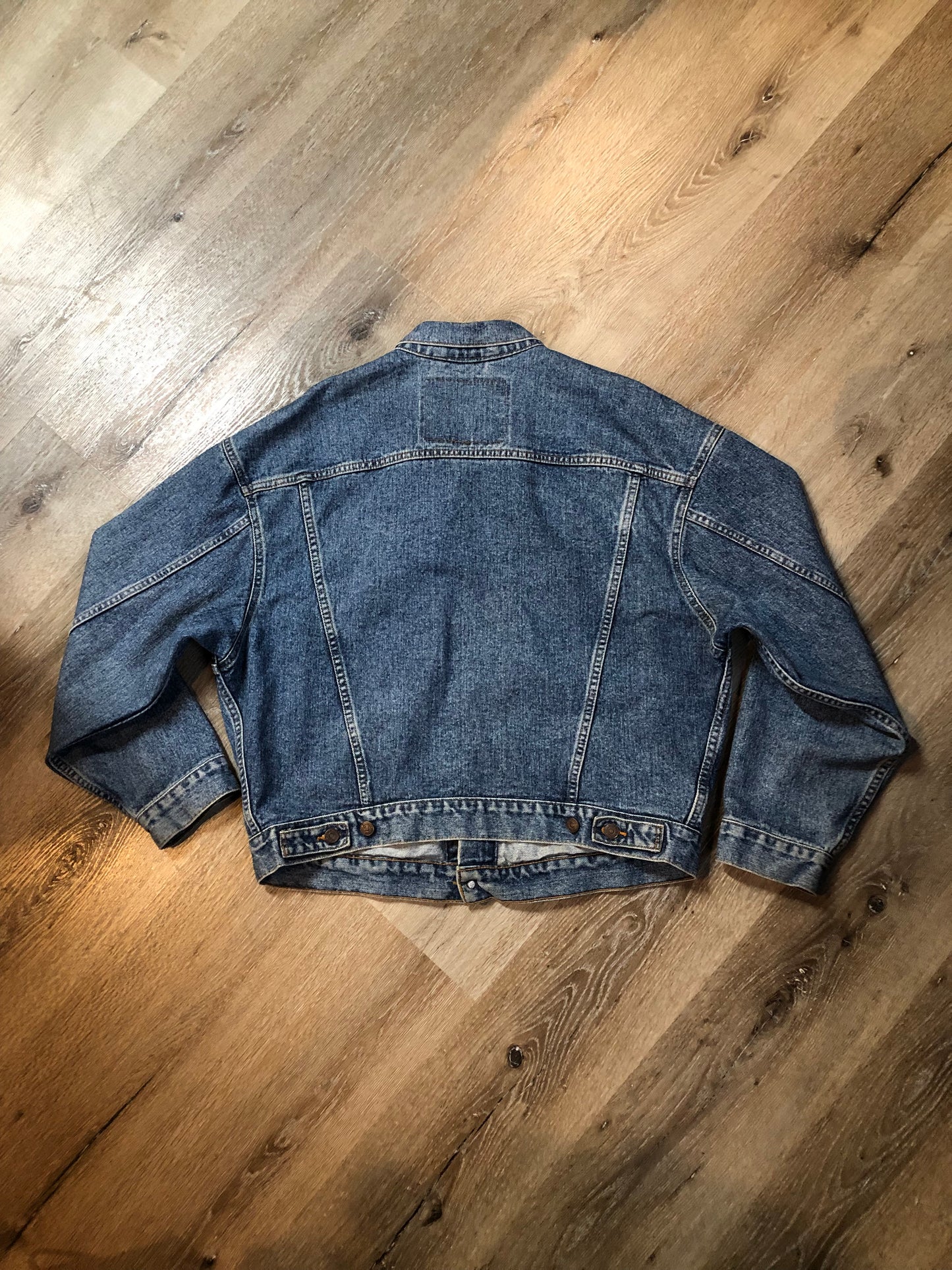 Vintage 1980’s Levi’s medium wash denim trucker jacket with button closures, two flap pockets on the chest, two side pockets and two inside pockets. Red Tab, 100% cotton, size large -Kingspier Vintage