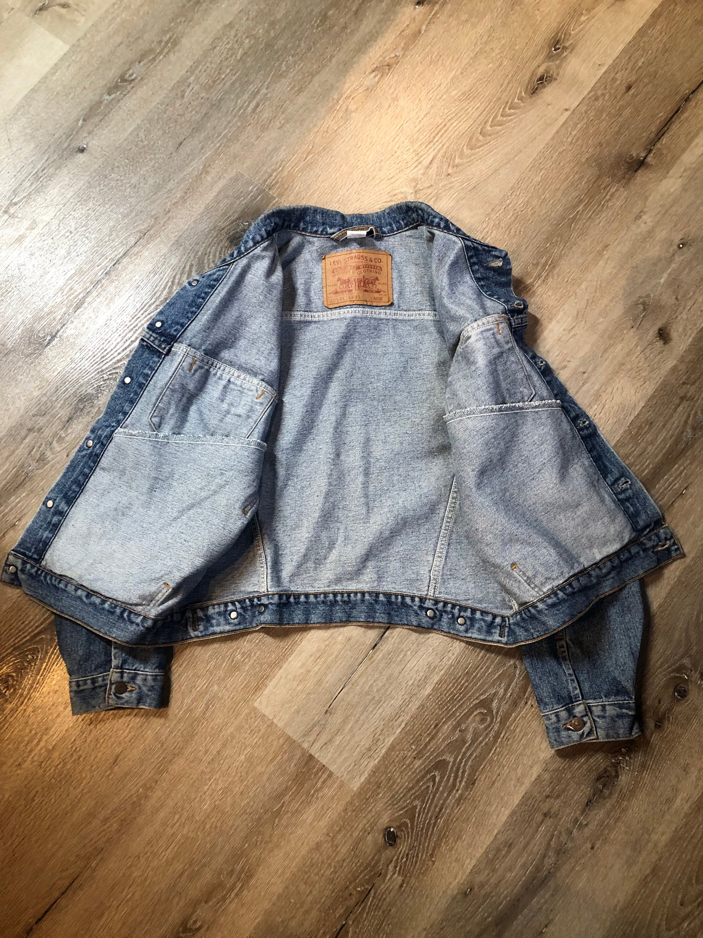 Vintage 1980’s Levi’s medium wash denim trucker jacket with button closures, two flap pockets on the chest, two side pockets and two inside pockets. Red Tab, 100% cotton, size large -Kingspier Vintage