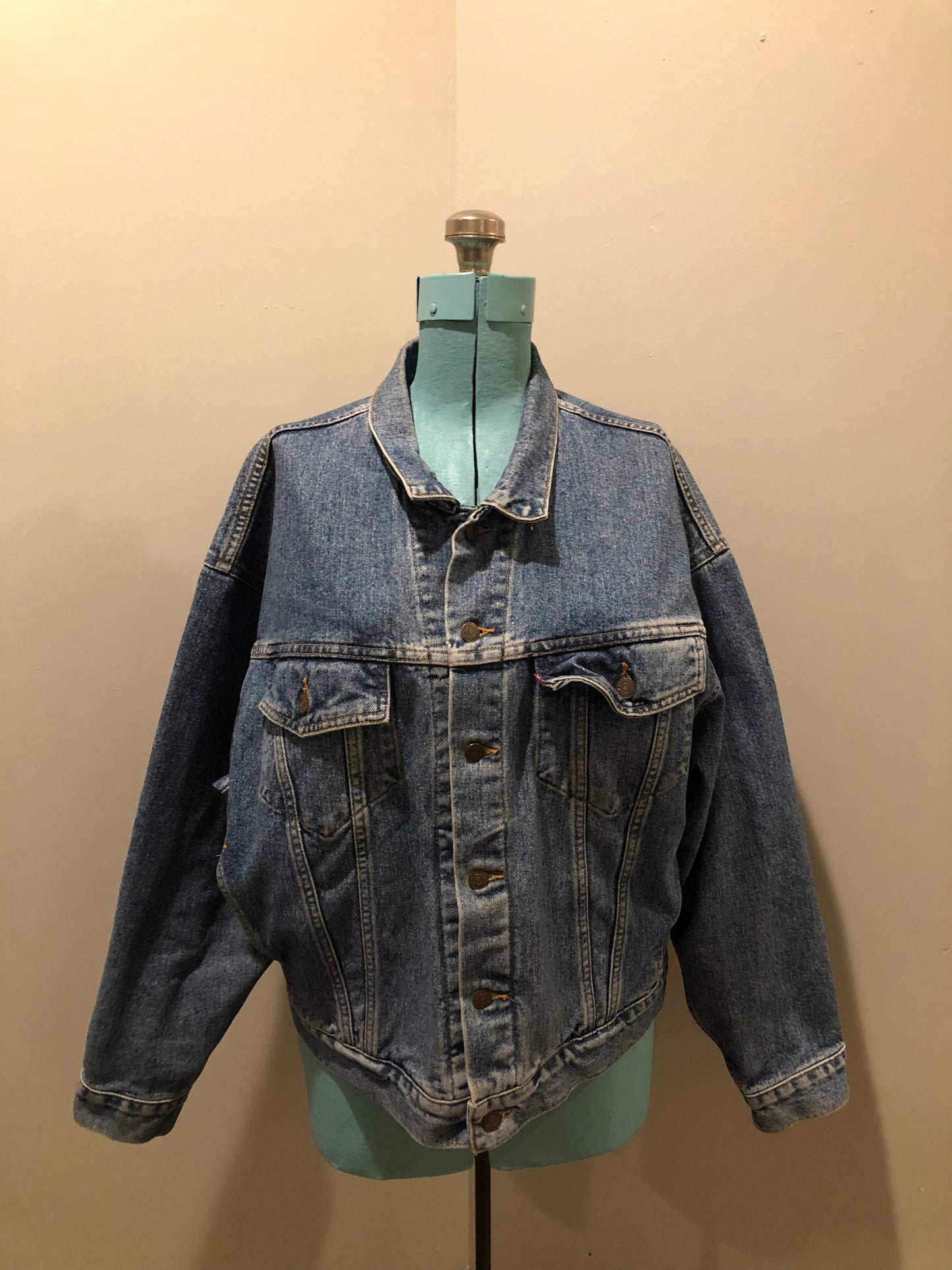 Vintage 1980’s Levi’s medium wash denim trucker jacket with button closures, two flap pockets on the chest, two side pockets and two inside pockets. Red Tab, 100% cotton, size large -Kingspier Vintage