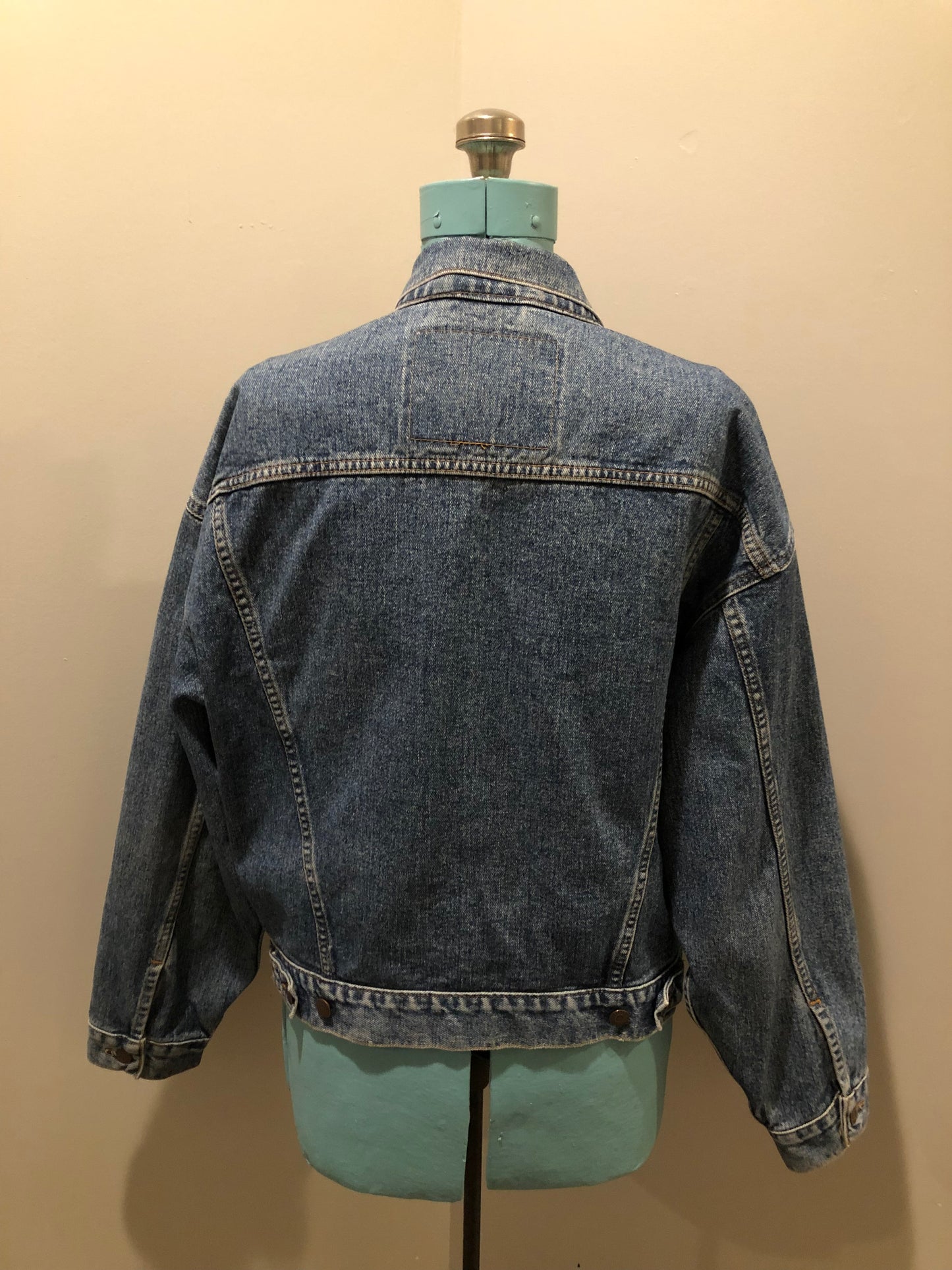 Vintage 1980’s Levi’s medium wash denim trucker jacket with button closures, two flap pockets on the chest, two side pockets and two inside pockets. Red Tab, 100% cotton, size large -Kingspier Vintage