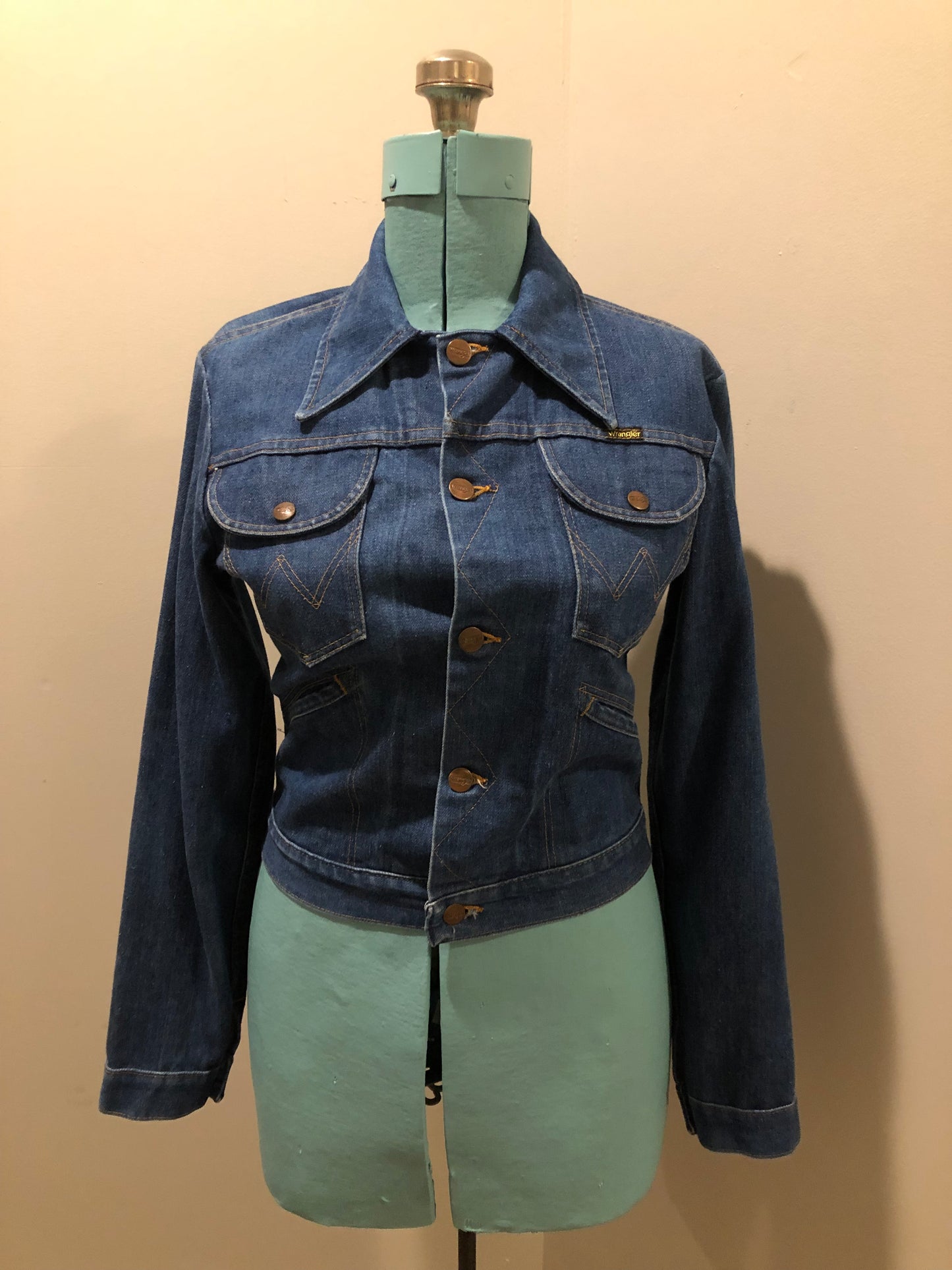 Vintage Wrangler medium wash denim jacket with button closures, two flap pockets on the chest and two hand warmer pockets in the front. 100% cotton, made in Canada, size 32 - Kingspier Vintage