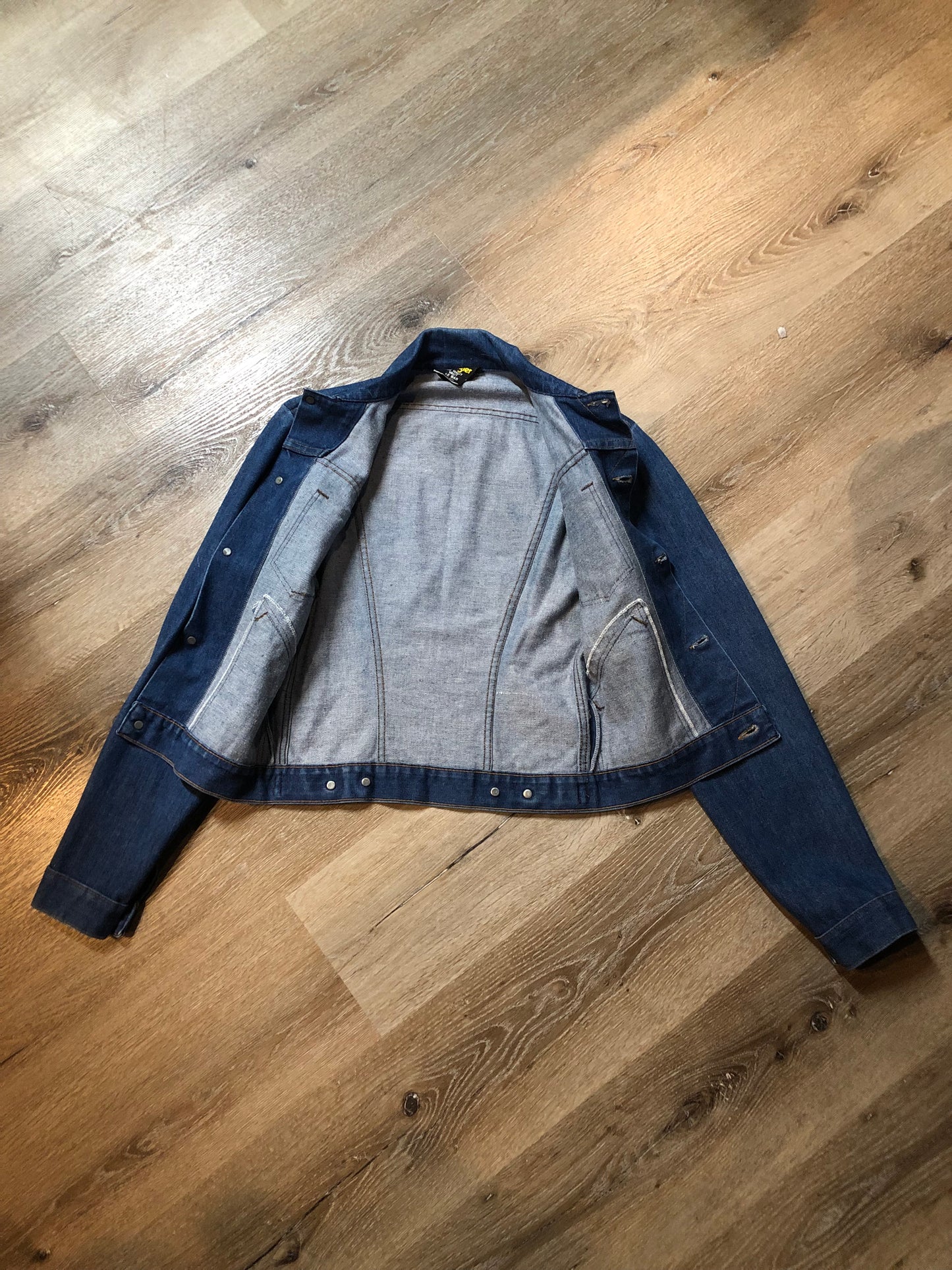 Vintage Wrangler medium wash denim jacket with button closures, two flap pockets on the chest and two hand warmer pockets in the front. 100% cotton, made in Canada, size 32 - Kingspier Vintage
