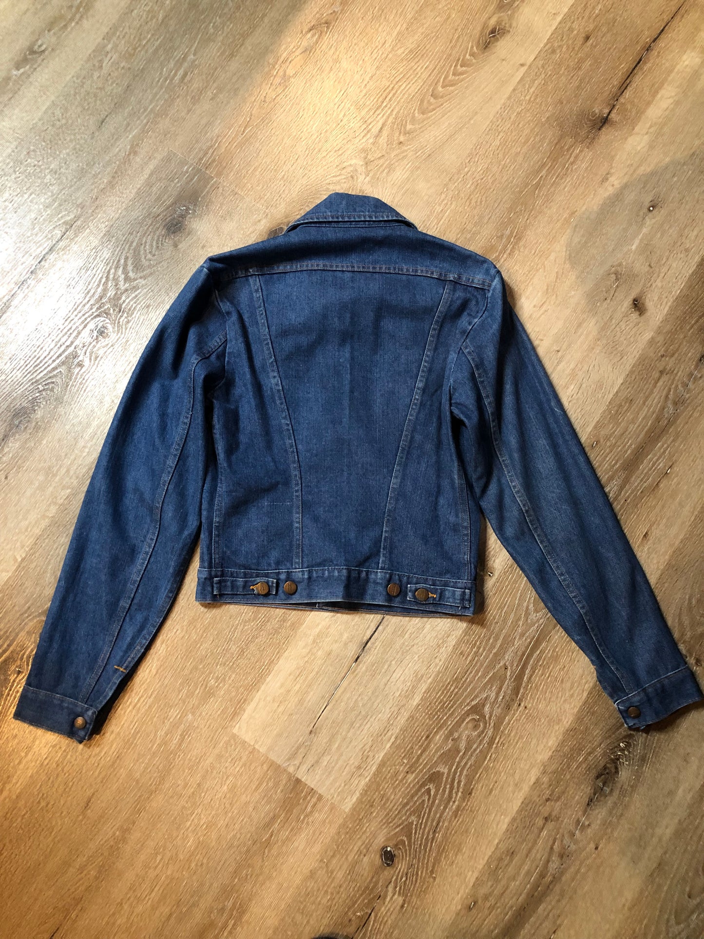 Vintage Wrangler medium wash denim jacket with button closures, two flap pockets on the chest and two hand warmer pockets in the front. 100% cotton, made in Canada, size 32 - Kingspier Vintage