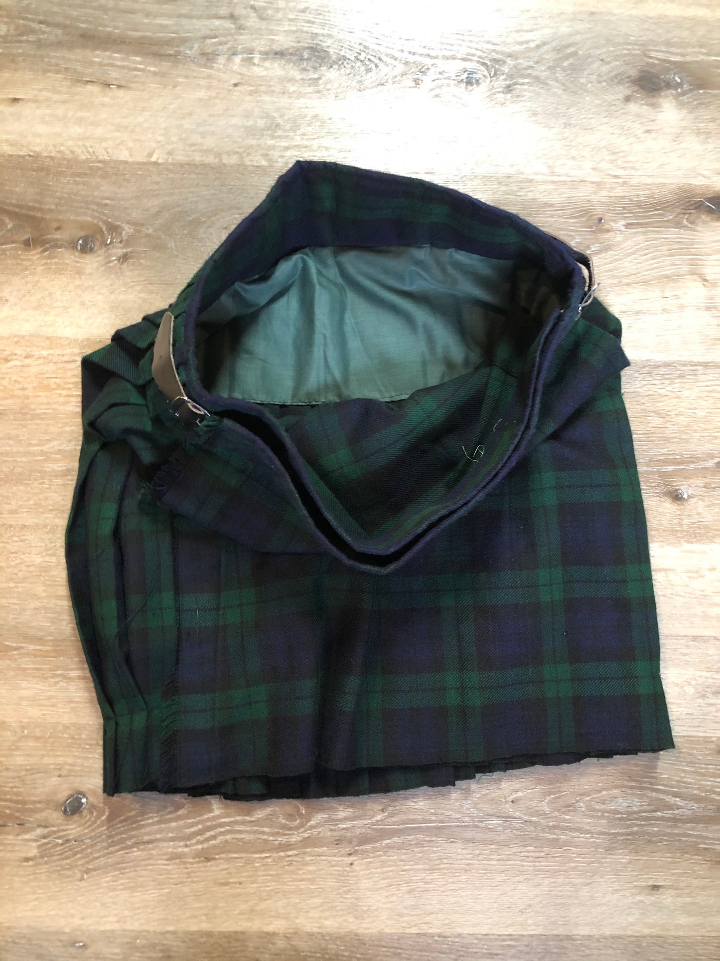 Kingspier Vintage - Black Watch tartan kilt with leather straps on each side to adjust size and fringed top skirt. Kilt is partially lined. Fibres unknown.