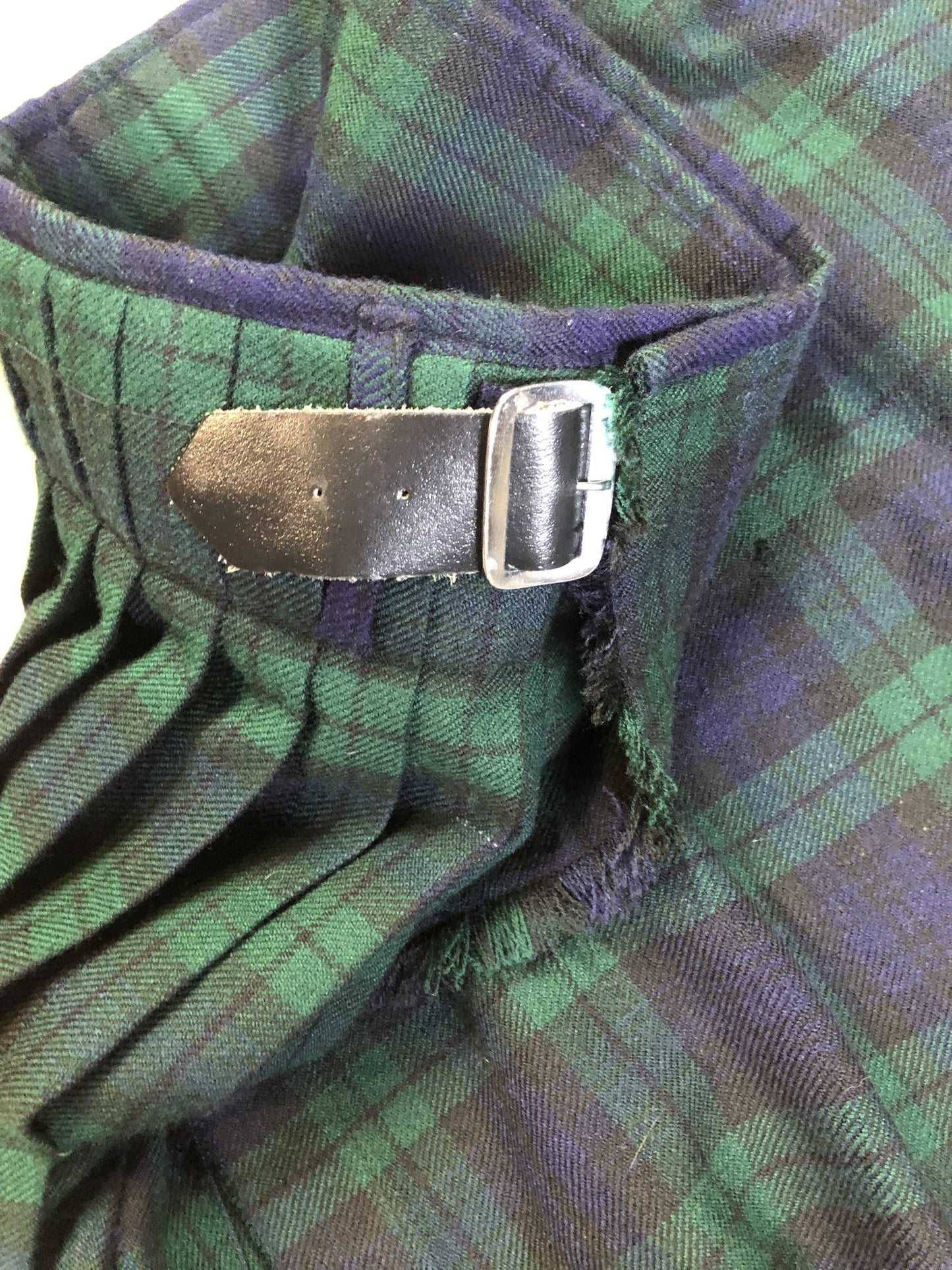 Kingspier Vintage - Black Watch tartan kilt with leather straps on each side to adjust size and fringed top skirt. Kilt is partially lined. Fibres unknown.