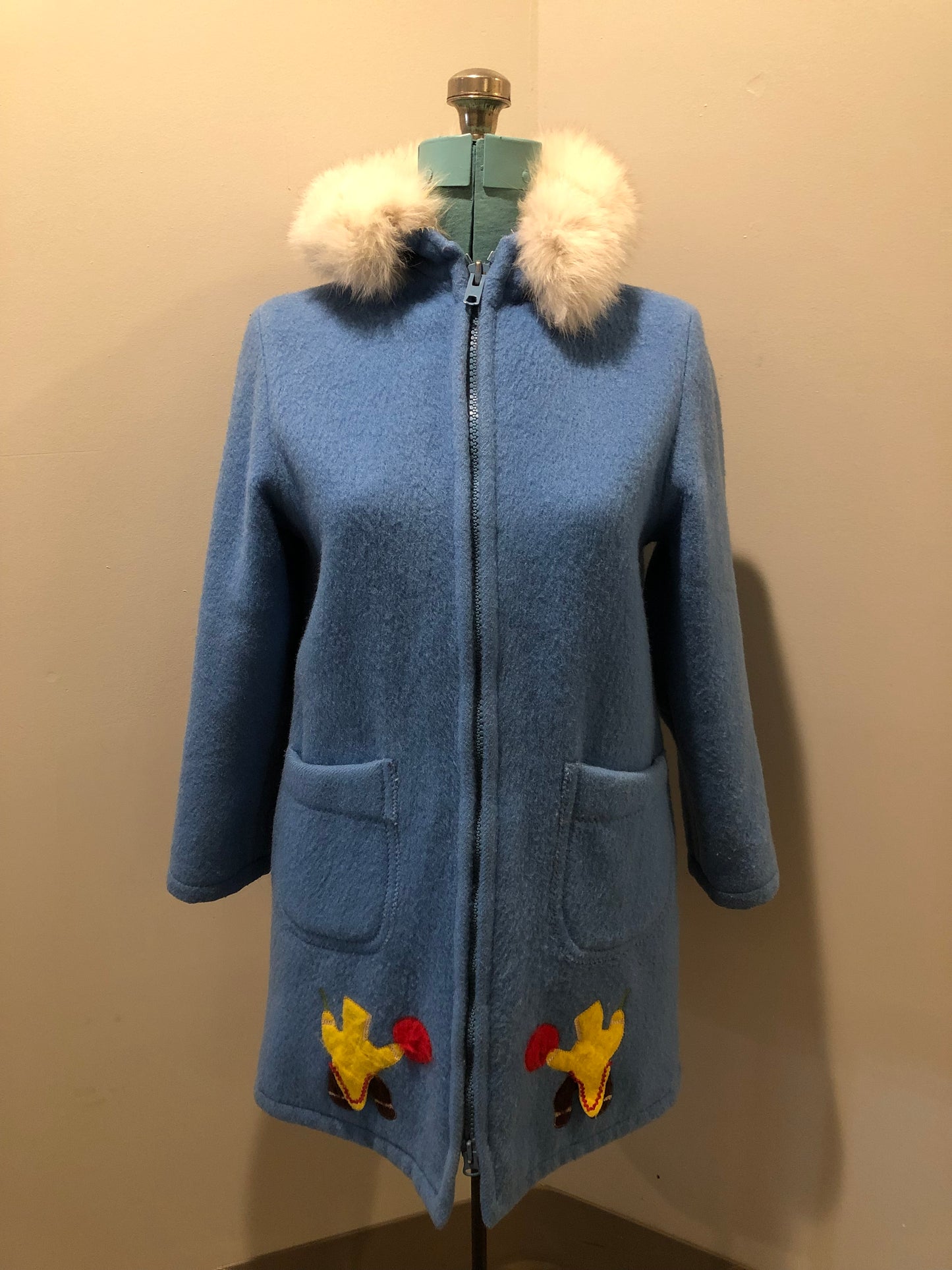 Vintage Hudson’s Bay Company 100% pure wool northern parka in sky blue. This parka features a fur trimmed hood, zipper closure, patch pockets, purple satin lining and a drumming and dance design in felt applique. Made in Canada by the Inuvik Parka Company - Kingspier Vintage