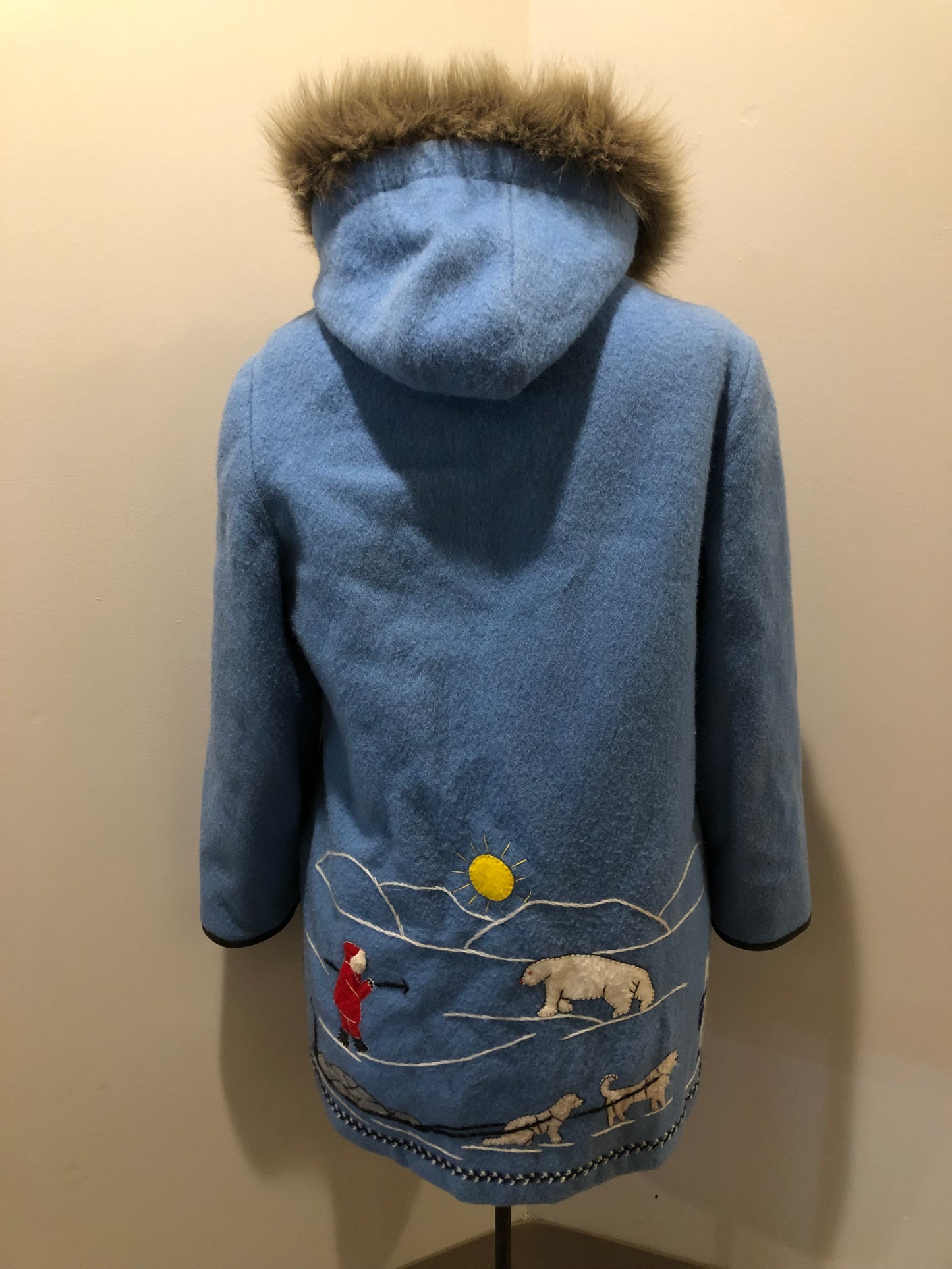 Vintage James Bay 100% pure wool northern parka in sky blue. This parka features a fur trimmed hood, zipper closure, patch pockets, quilted lining, storm cuffs, leather trim, embroidery details and a northern life design in felt applique. Made in Canada. Size 12 - Kingspier Vintage