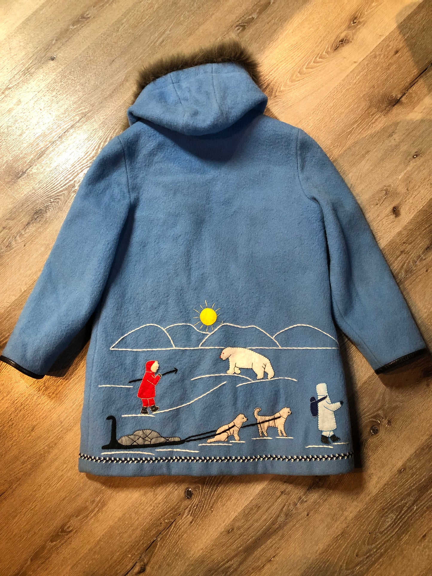 Vintage James Bay 100% pure wool northern parka in sky blue. This parka features a fur trimmed hood, zipper closure, patch pockets, quilted lining, storm cuffs, leather trim, embroidery details and a northern life design in felt applique. Made in Canada. Size 12 - Kingspier Vintage