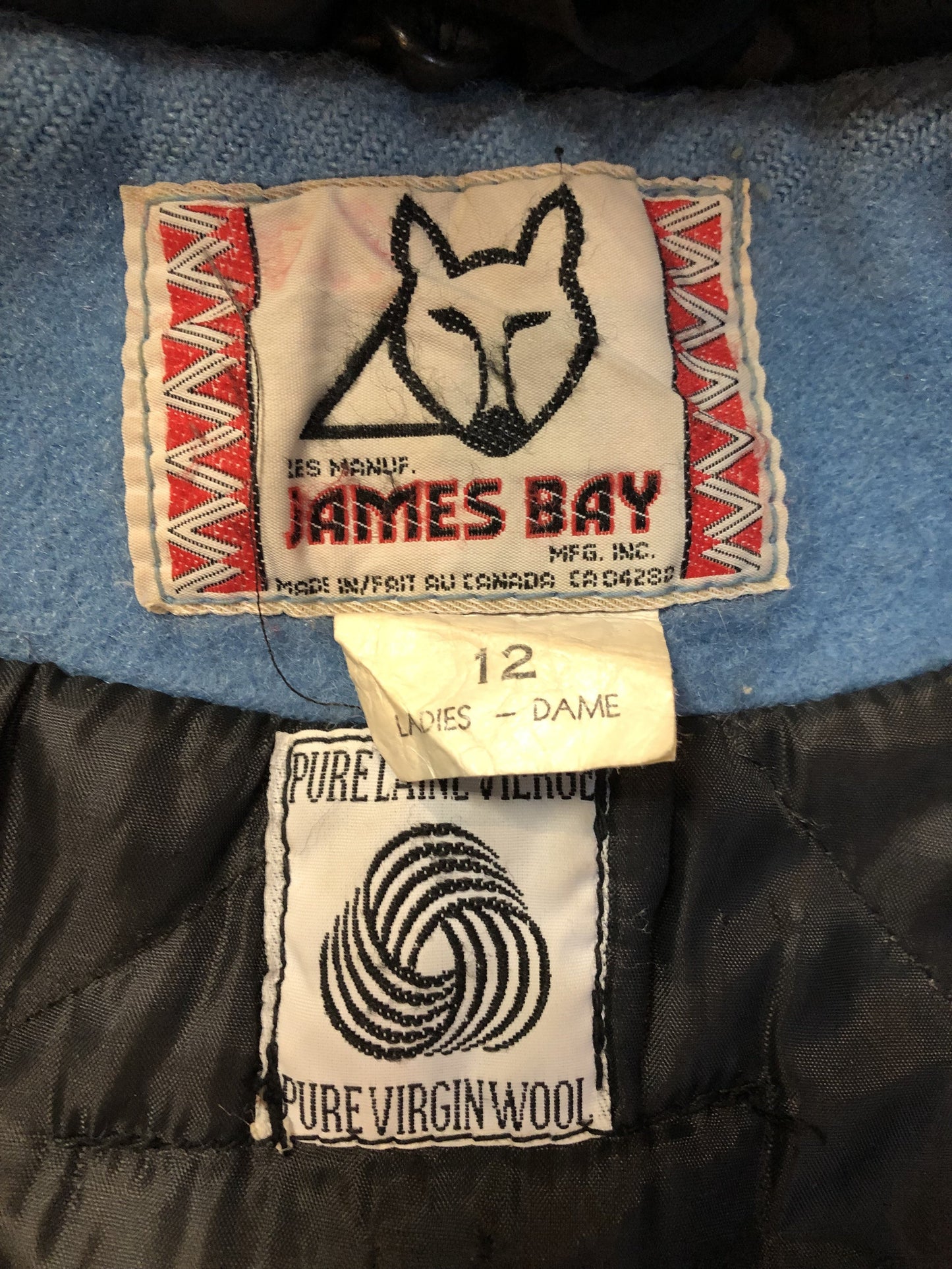 Vintage James Bay 100% pure wool northern parka in sky blue. This parka features a fur trimmed hood, zipper closure, patch pockets, quilted lining, storm cuffs, leather trim, embroidery details and a northern life design in felt applique. Made in Canada. Size 12 - Kingspier Vintage