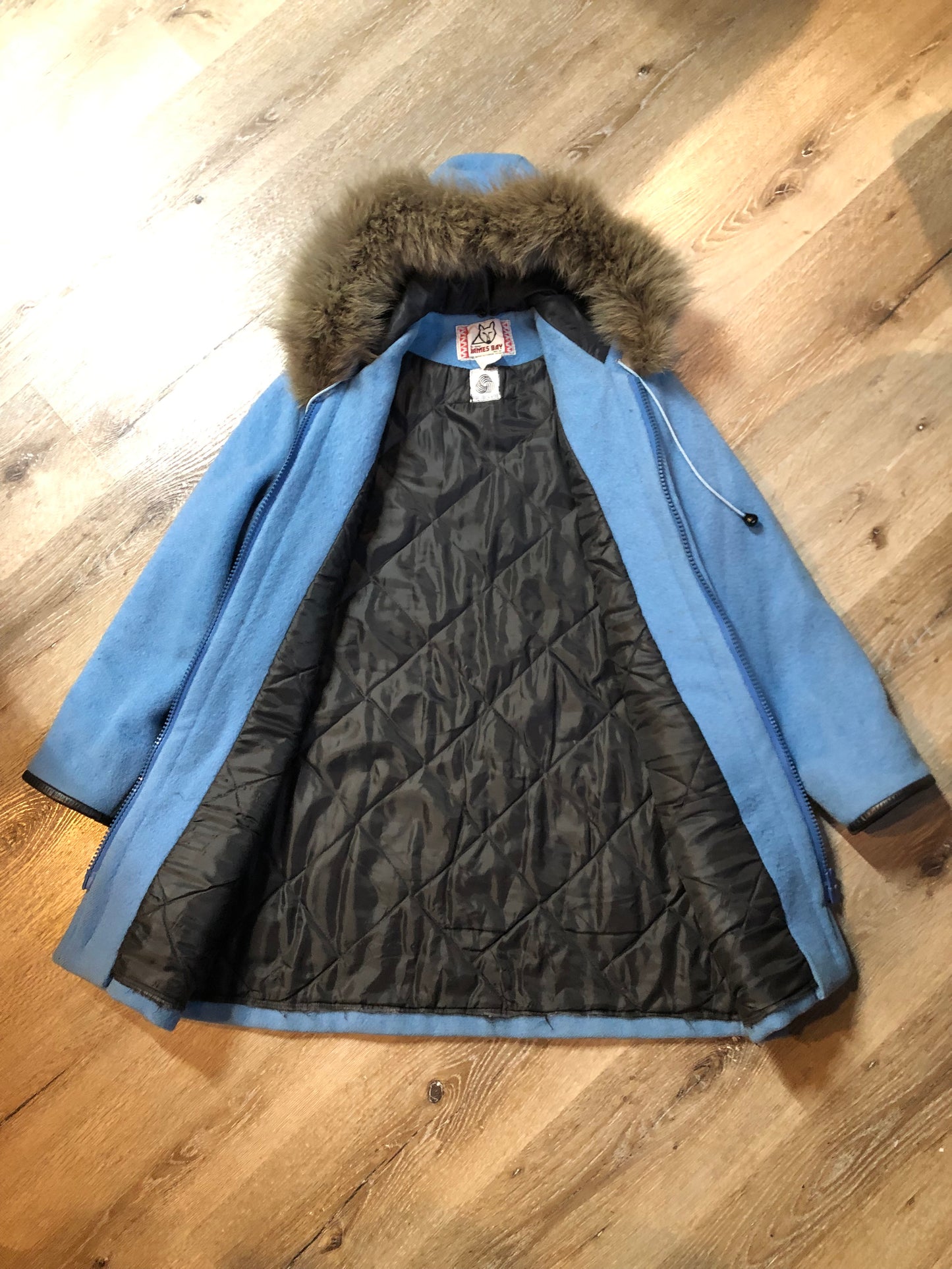 Vintage James Bay 100% pure wool northern parka in sky blue. This parka features a fur trimmed hood, zipper closure, patch pockets, quilted lining, storm cuffs, leather trim, embroidery details and a northern life design in felt applique. Made in Canada. Size 12 - Kingspier Vintage