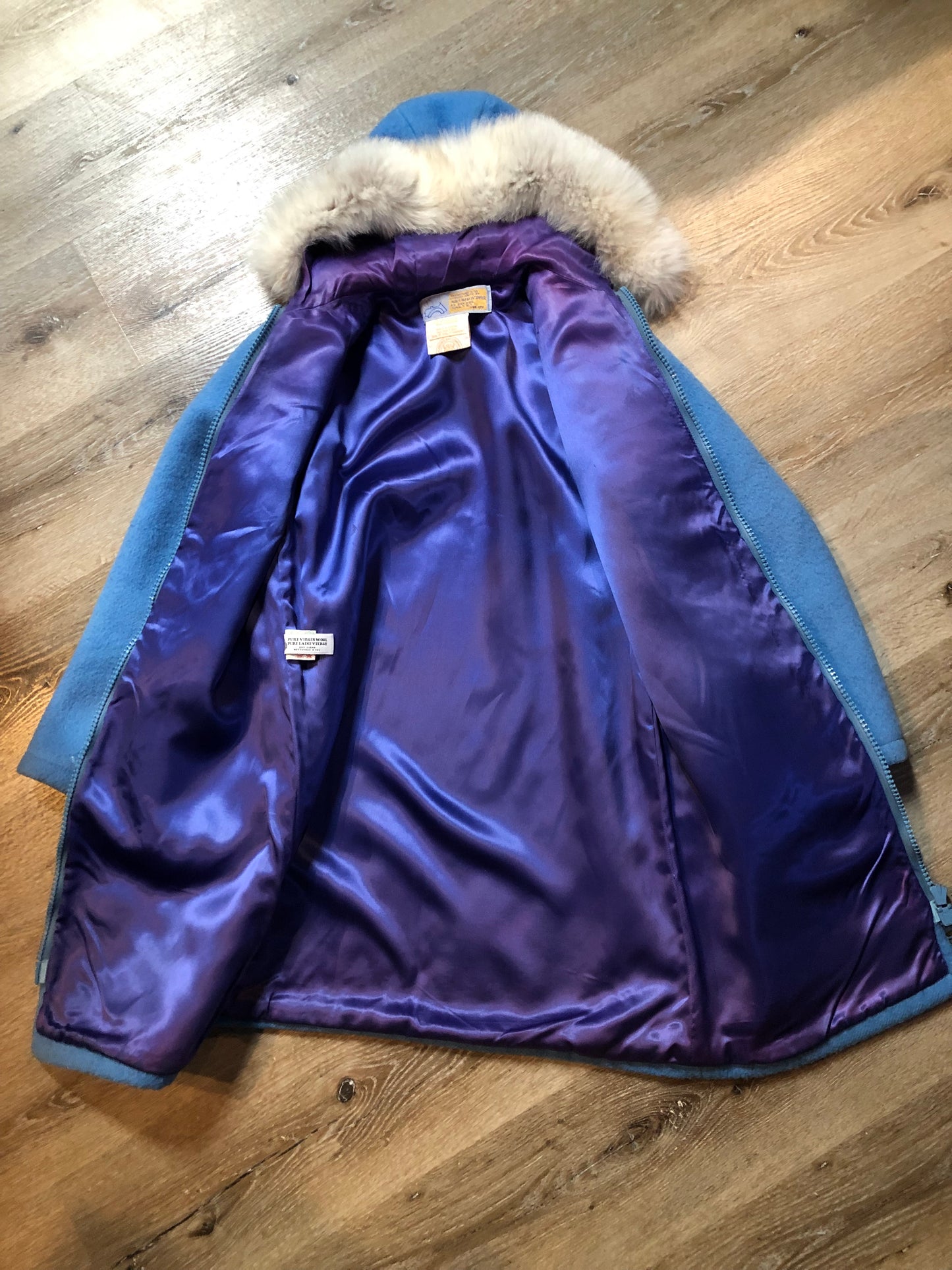Vintage Hudson’s Bay Company 100% pure wool northern parka in sky blue. This parka features a fur trimmed hood, zipper closure, patch pockets, purple satin lining and a drumming and dance design in felt applique. Made in Canada by the Inuvik Parka Company - Kingspier Vintage