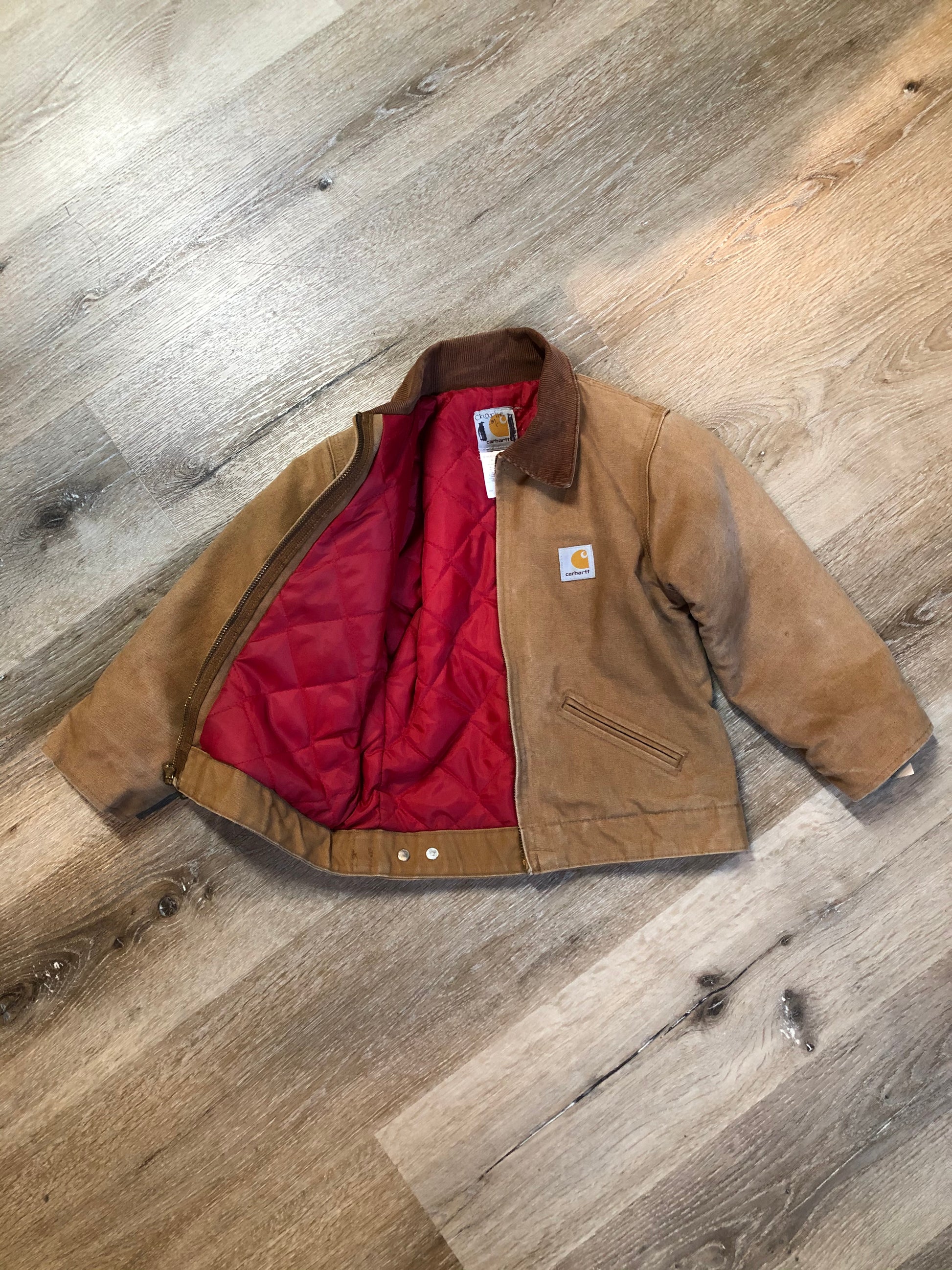 Kingspier Vintage - Kids Carhartt Chore Jacket in Tan Brown with Brown corduroy collar, zipper closure, slash pockets, knit inner cuffs and red quilted lining. Made in the USA. Size childrens 6.