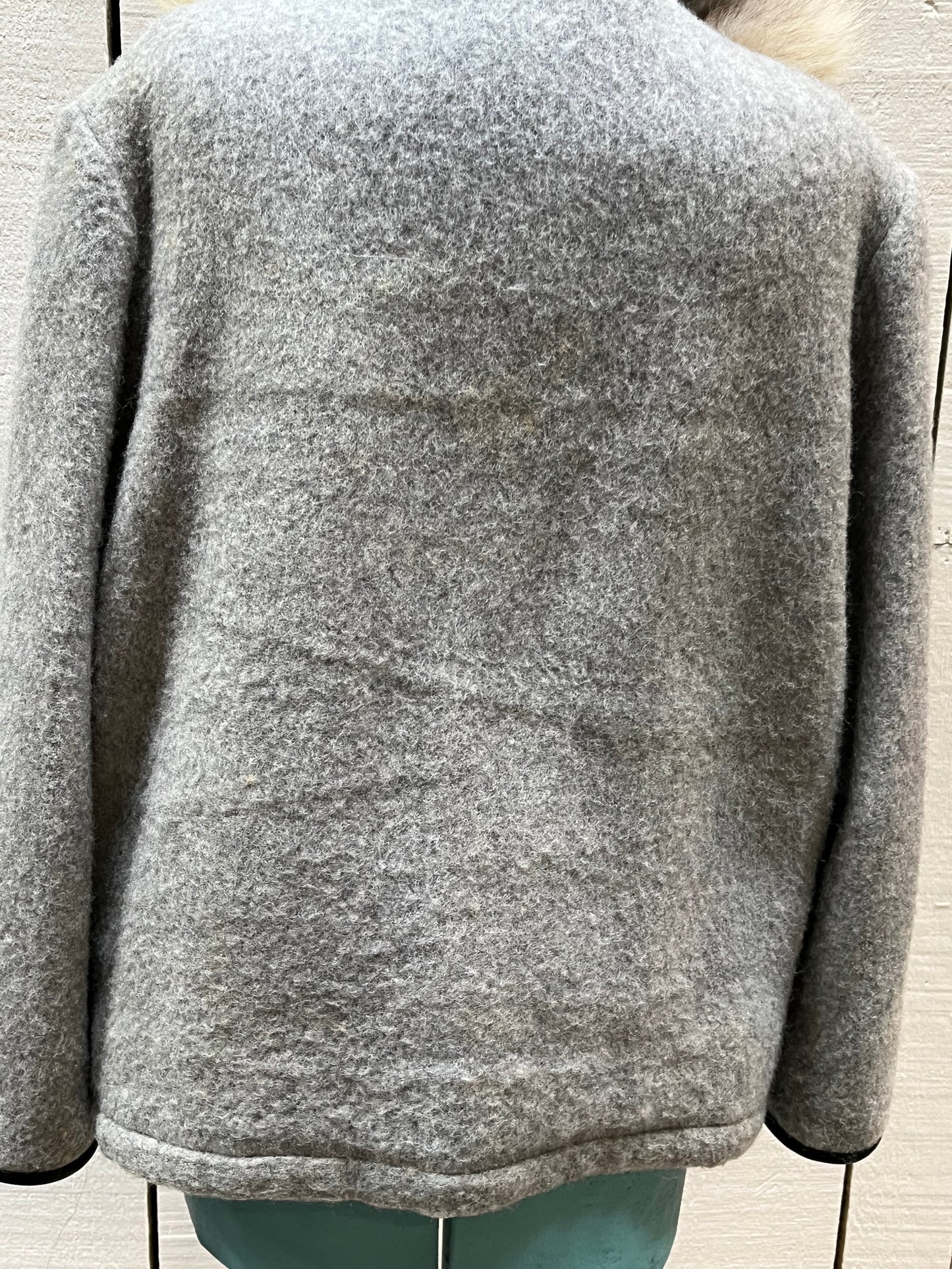 Vintage James Bay100% wool grey northern parka with fox fur trimmed hood, zipper closure, zip front pockets, leather trimmed cuffs, drawstring at waist, quilted lining and felt applique in a seal motif.
Made in Canada
Chest 44”
