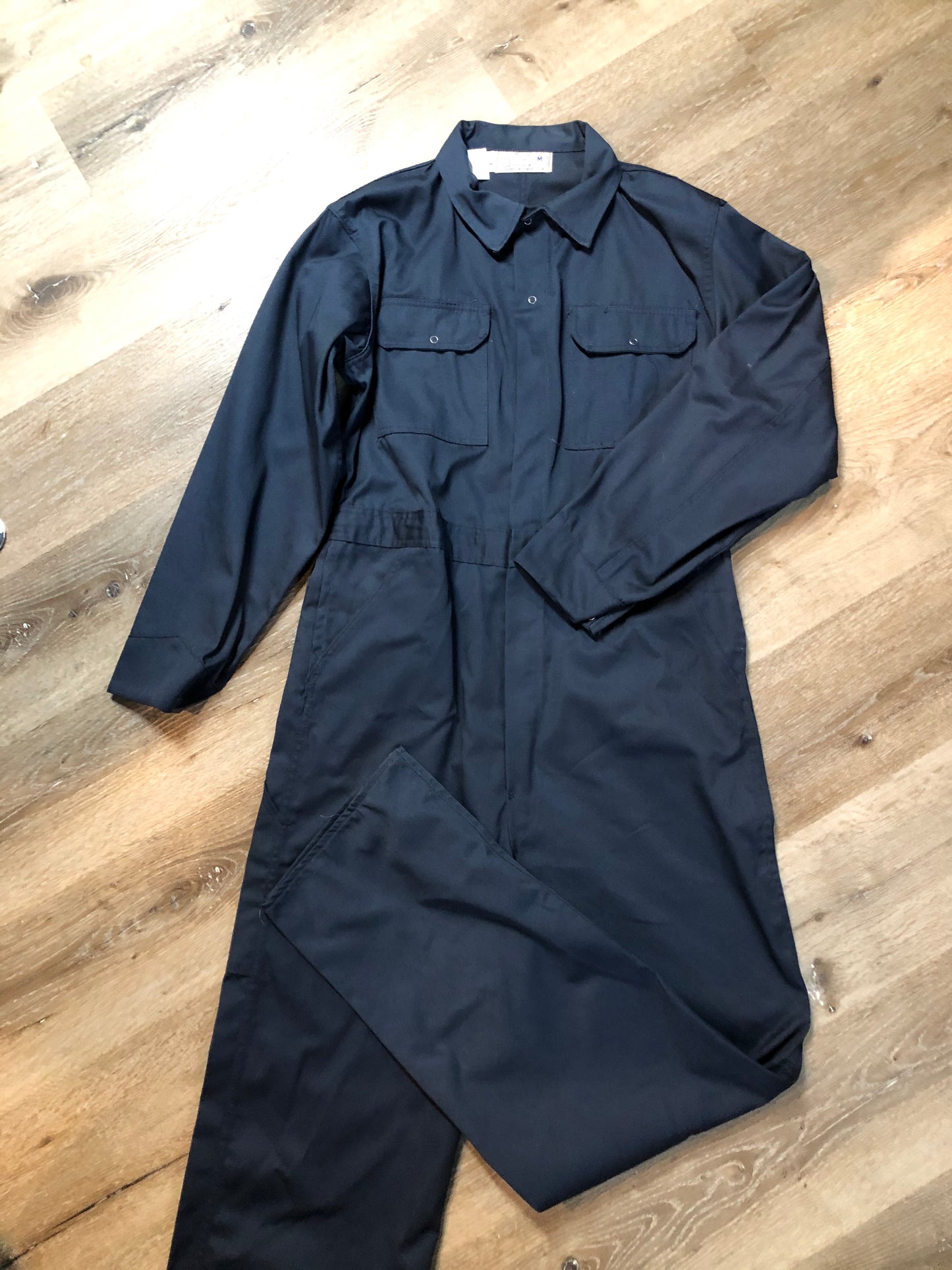 Kingspier Vintage - Vintage Deadstock Anchor Textiles navy coveralls with snap closures, flap pockets on the chest, slash pockets in the front and patch pockets in the back. Union made in Canada. Size medium/ tall.