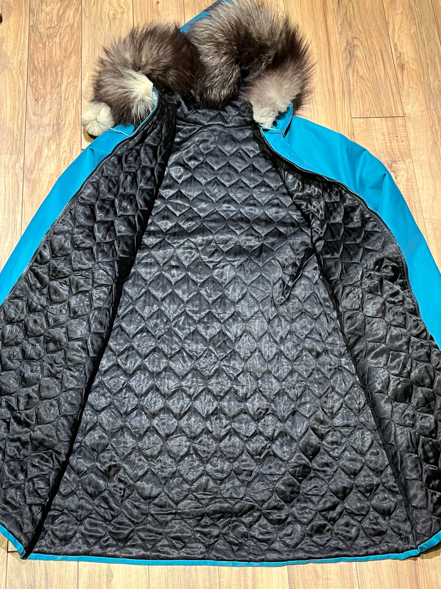 Vintage teal northern parka with fur trimmed hood, fur pom poms, zipper closure, patch pockets in the front and hand embroidered details.
Chest 46”