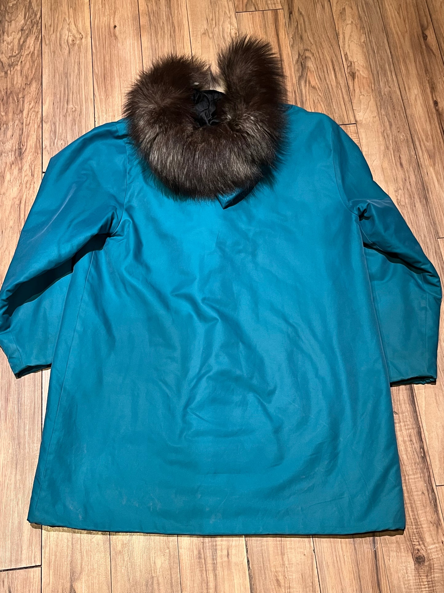 Vintage teal northern parka with fur trimmed hood, fur pom poms, zipper closure, patch pockets in the front and hand embroidered details.
Chest 46”