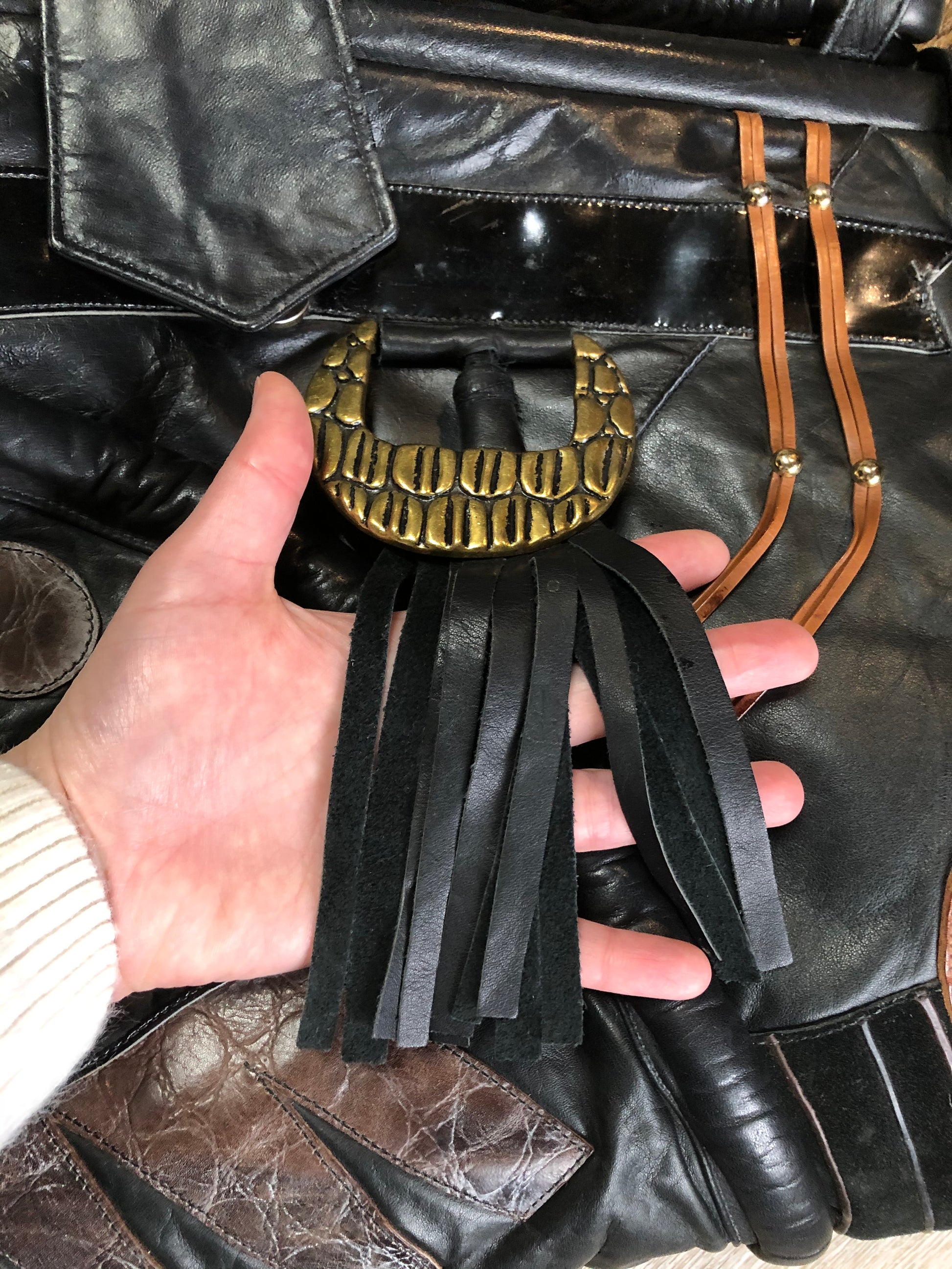 Kingspier Vintage - Upcycled leather bag with top handle, loops to attach a longer strap. (strap not included), snap closures, dinosaur and wooly mammoth design, a tassel and some other unique leather details.
Length - 18”
Width - 4”
Height - 13”
This bag is in great condition with some minor wear.