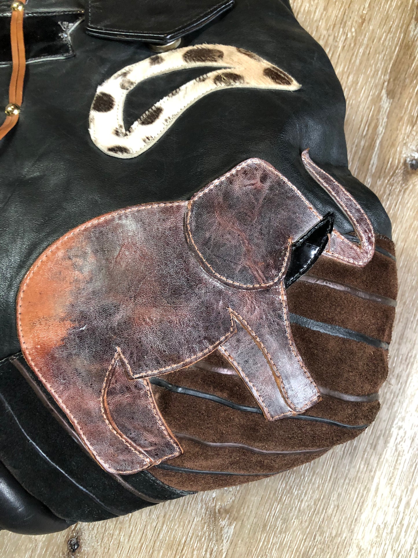 Kingspier Vintage - Upcycled leather bag with top handle, loops to attach a longer strap. (strap not included), snap closures, dinosaur and wooly mammoth design, a tassel and some other unique leather details.
Length - 18”
Width - 4”
Height - 13”
This bag is in great condition with some minor wear.