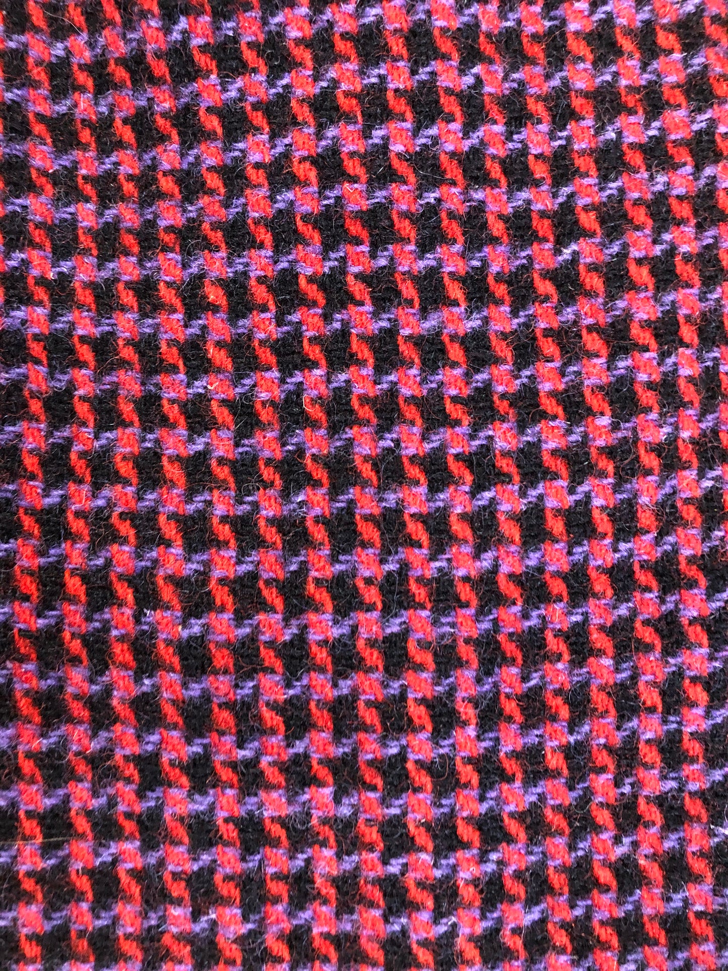 Kingspier Vintage - Mills Brothers red, black and blue houndstooth wool coat. The colours in the houndstooth come together to make a deep purple. This coat features button closures, vertical pockets, knit inner cuffs, a satin lining and zip out genuine chamois inner- lining. Made in Canada. Size medium/ large.
