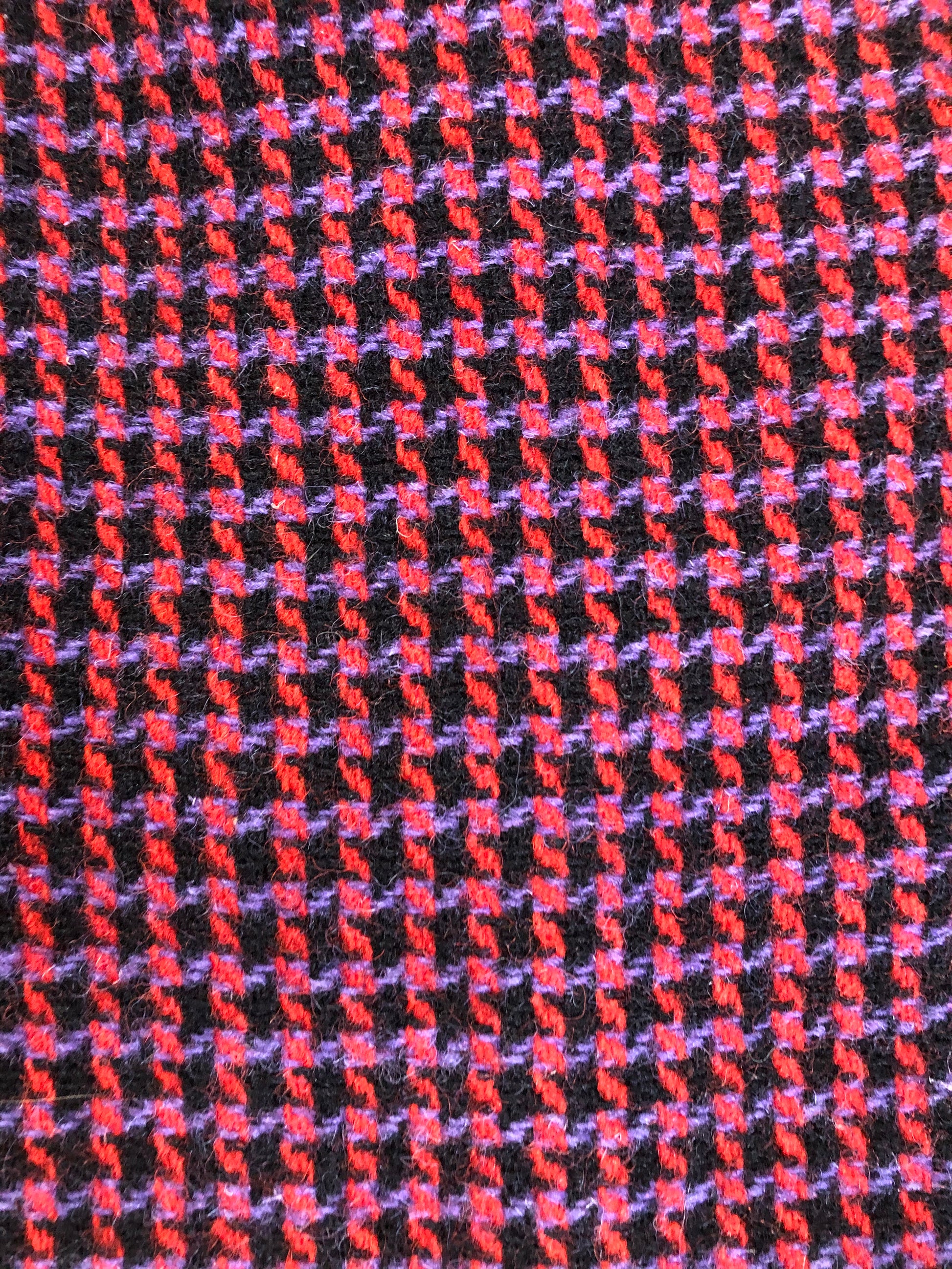 Kingspier Vintage - Mills Brothers red, black and blue houndstooth wool coat. The colours in the houndstooth come together to make a deep purple. This coat features button closures, vertical pockets, knit inner cuffs, a satin lining and zip out genuine chamois inner- lining. Made in Canada. Size medium/ large.