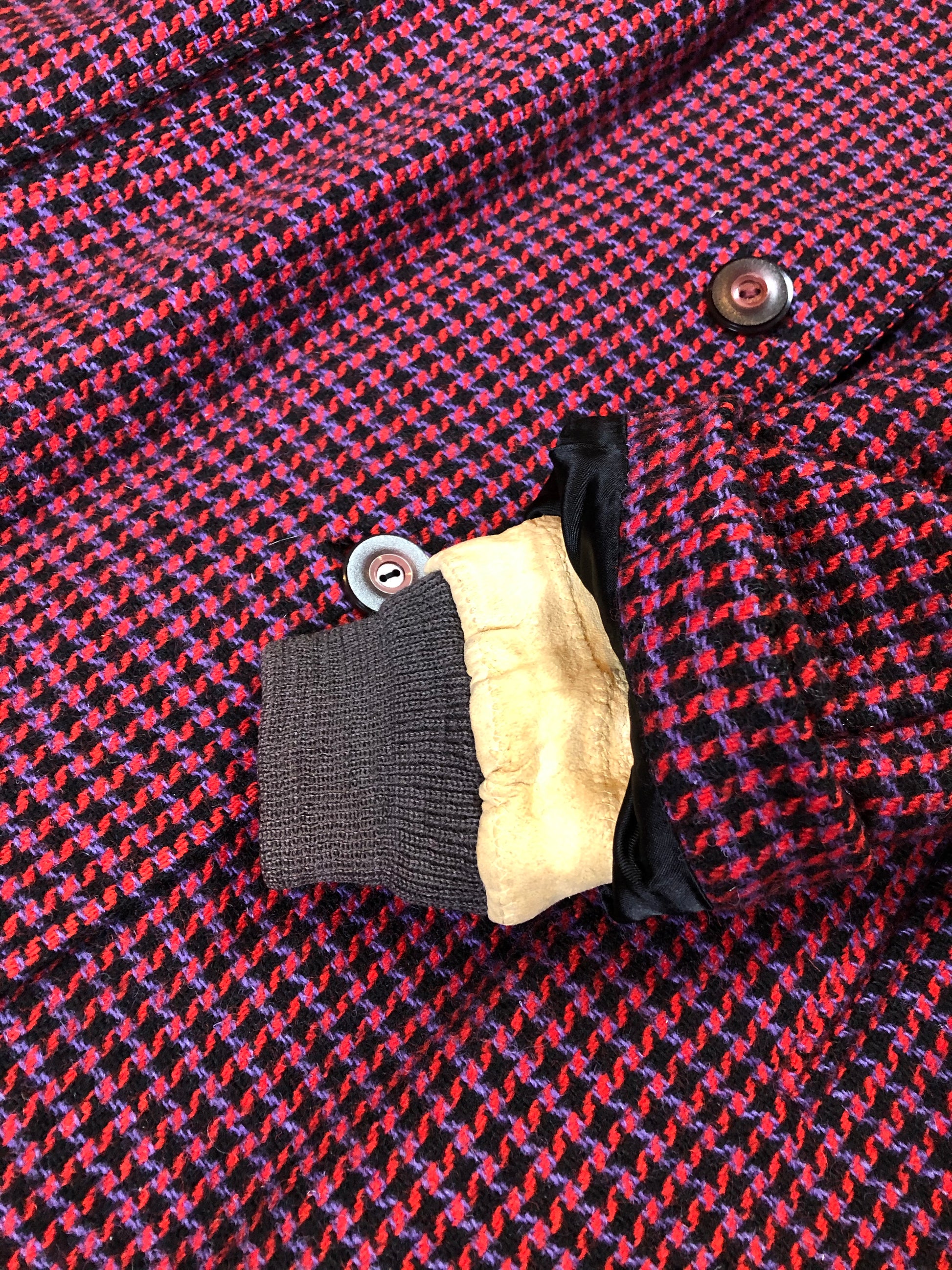 Kingspier Vintage - Mills Brothers red, black and blue houndstooth wool coat. The colours in the houndstooth come together to make a deep purple. This coat features button closures, vertical pockets, knit inner cuffs, a satin lining and zip out genuine chamois inner- lining. Made in Canada. Size medium/ large.