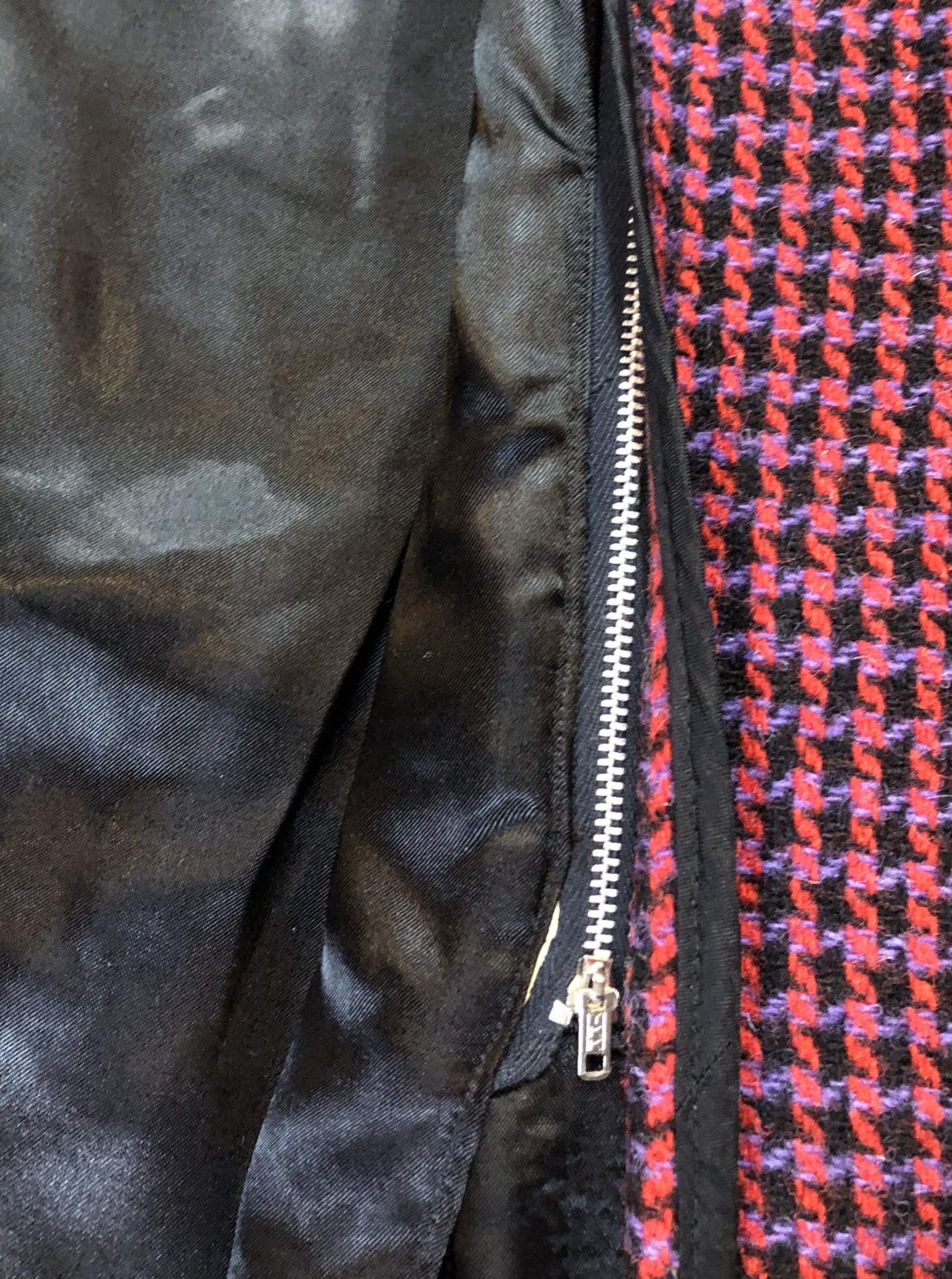 Kingspier Vintage - Mills Brothers red, black and blue houndstooth wool coat. The colours in the houndstooth come together to make a deep purple. This coat features button closures, vertical pockets, knit inner cuffs, a satin lining and zip out genuine chamois inner- lining. Made in Canada. Size medium/ large.