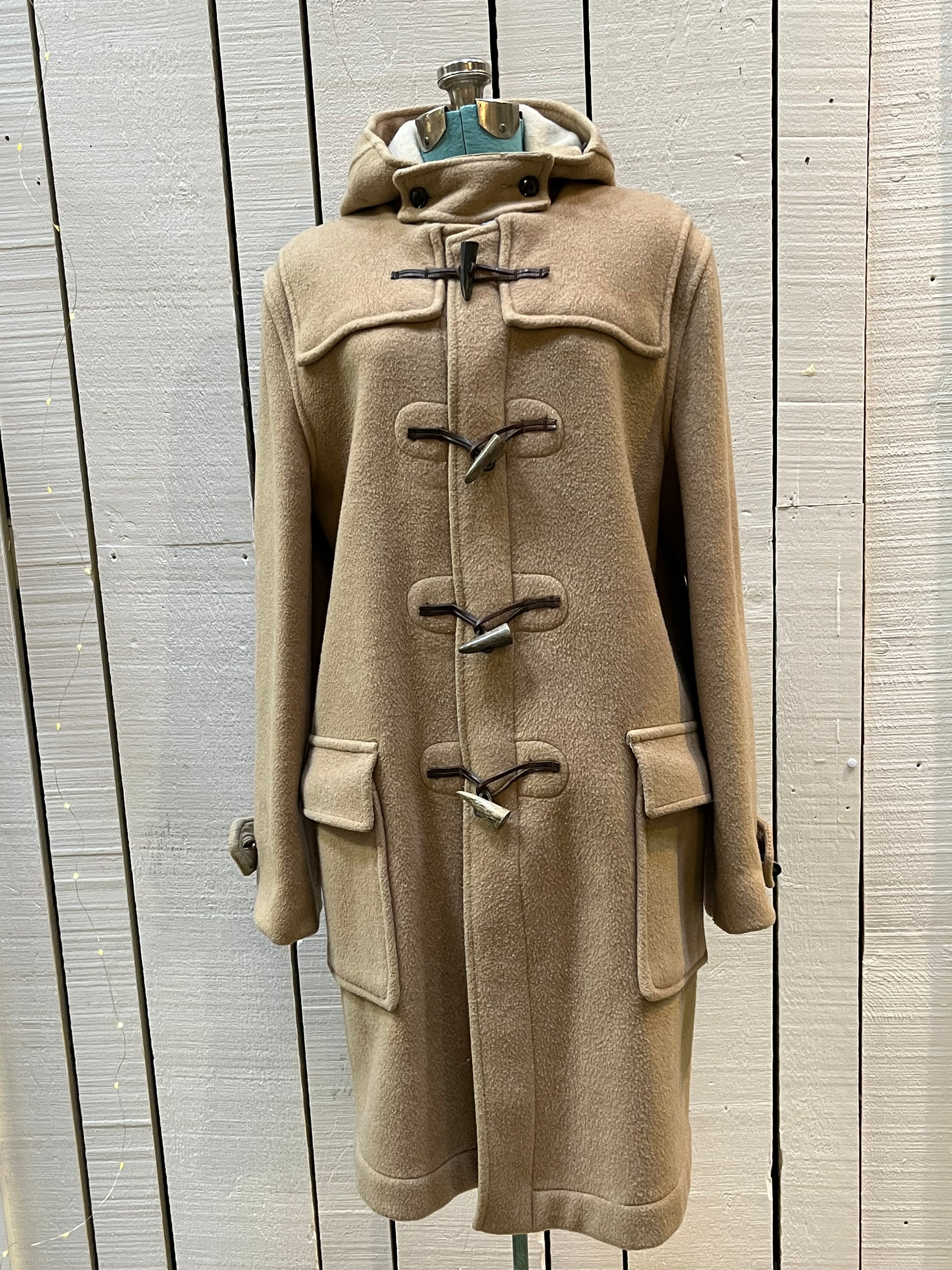Vintage Gloverall tan duffle coat, with zipper and horn toggle closures, hood and two flap pockets.
80% wool/ 20% polyester
Made in England
Size 52