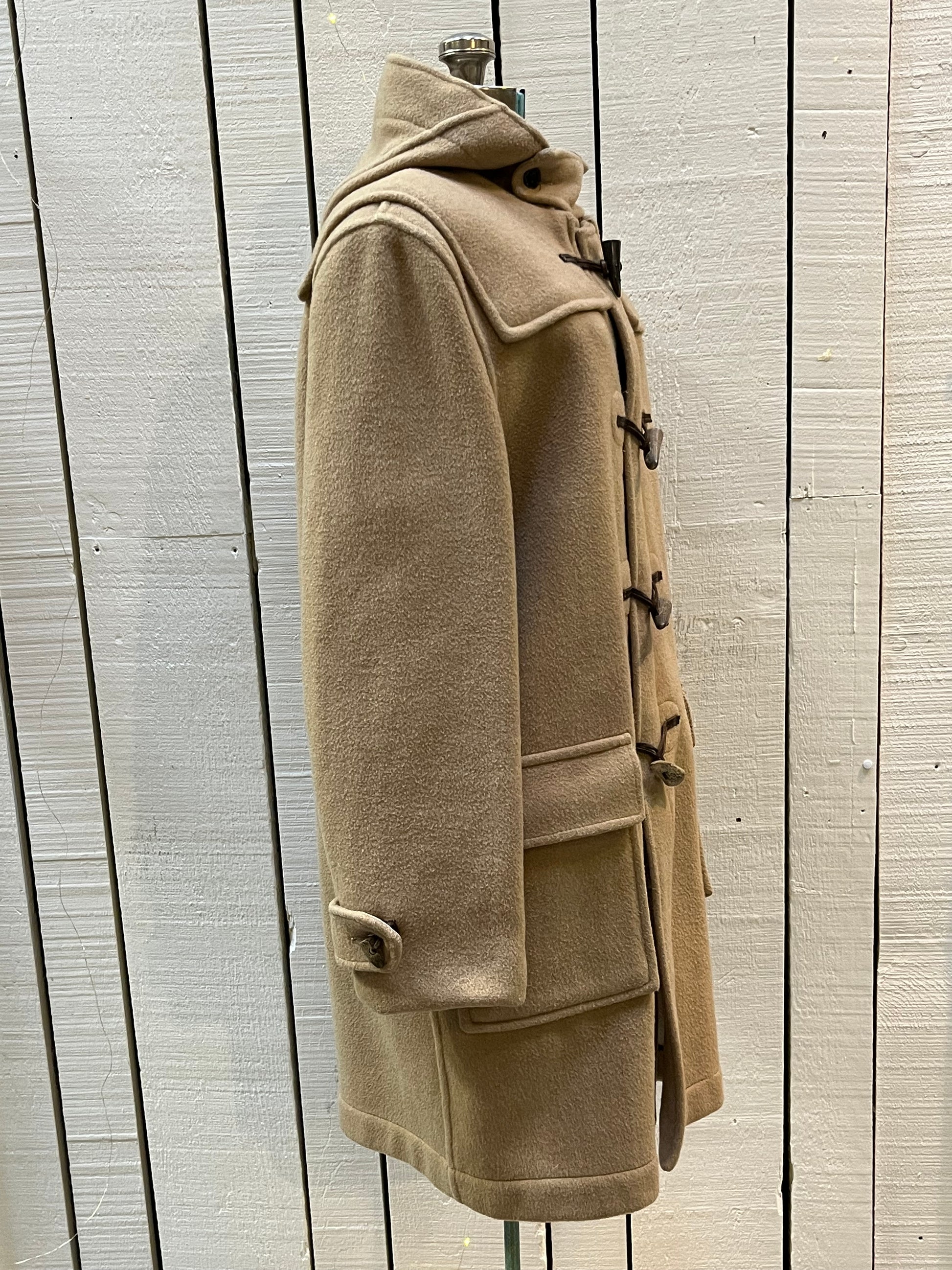 Vintage Gloverall tan duffle coat, with zipper and horn toggle closures, hood and two flap pockets.
80% wool/ 20% polyester
Made in England
Size 52