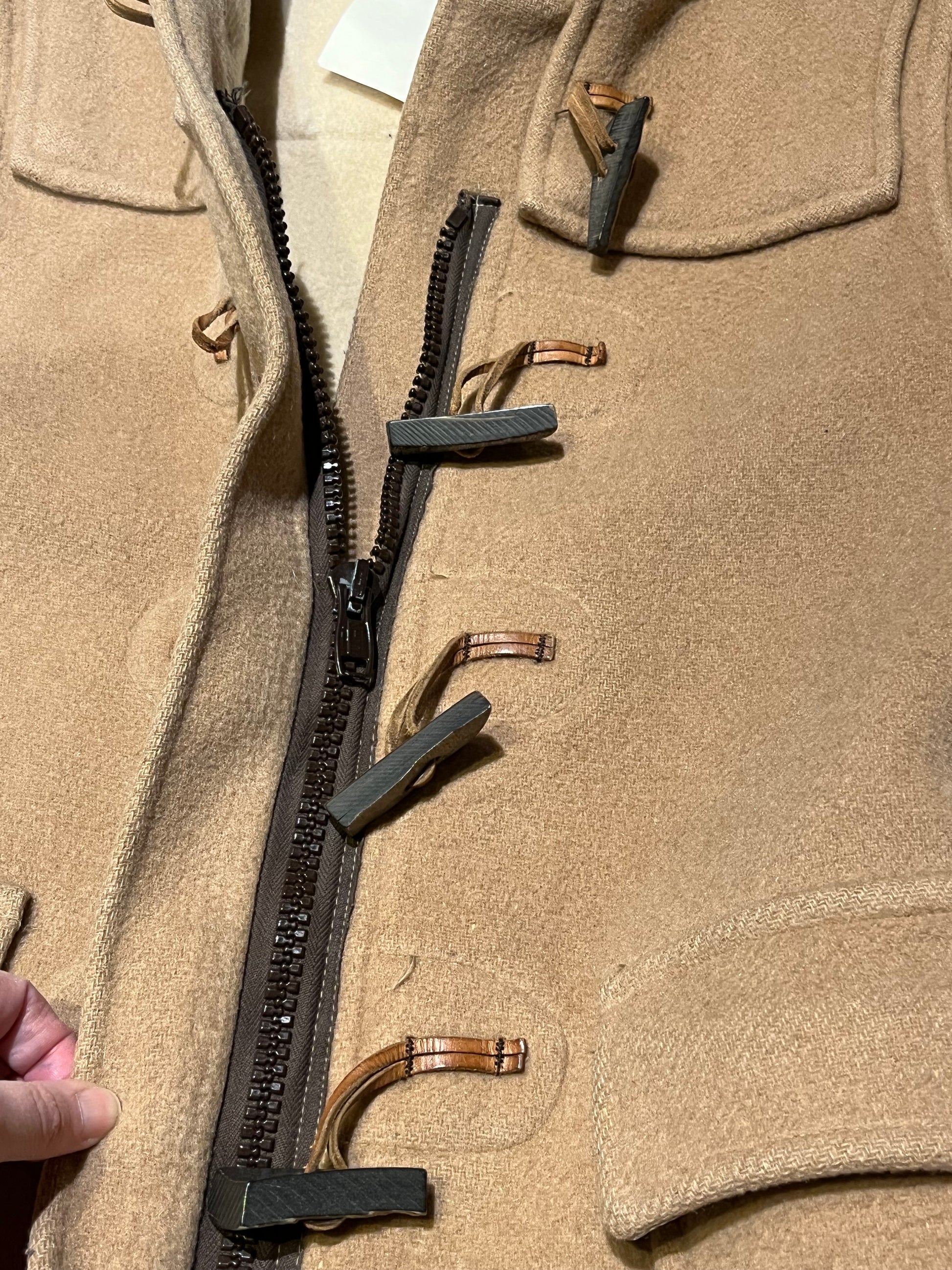 Vintage Gloverall tan duffle coat, with zipper and antler toggle closures, hood and two flap pockets.
80% wool/ 20% polyester
Made in England
Size 40