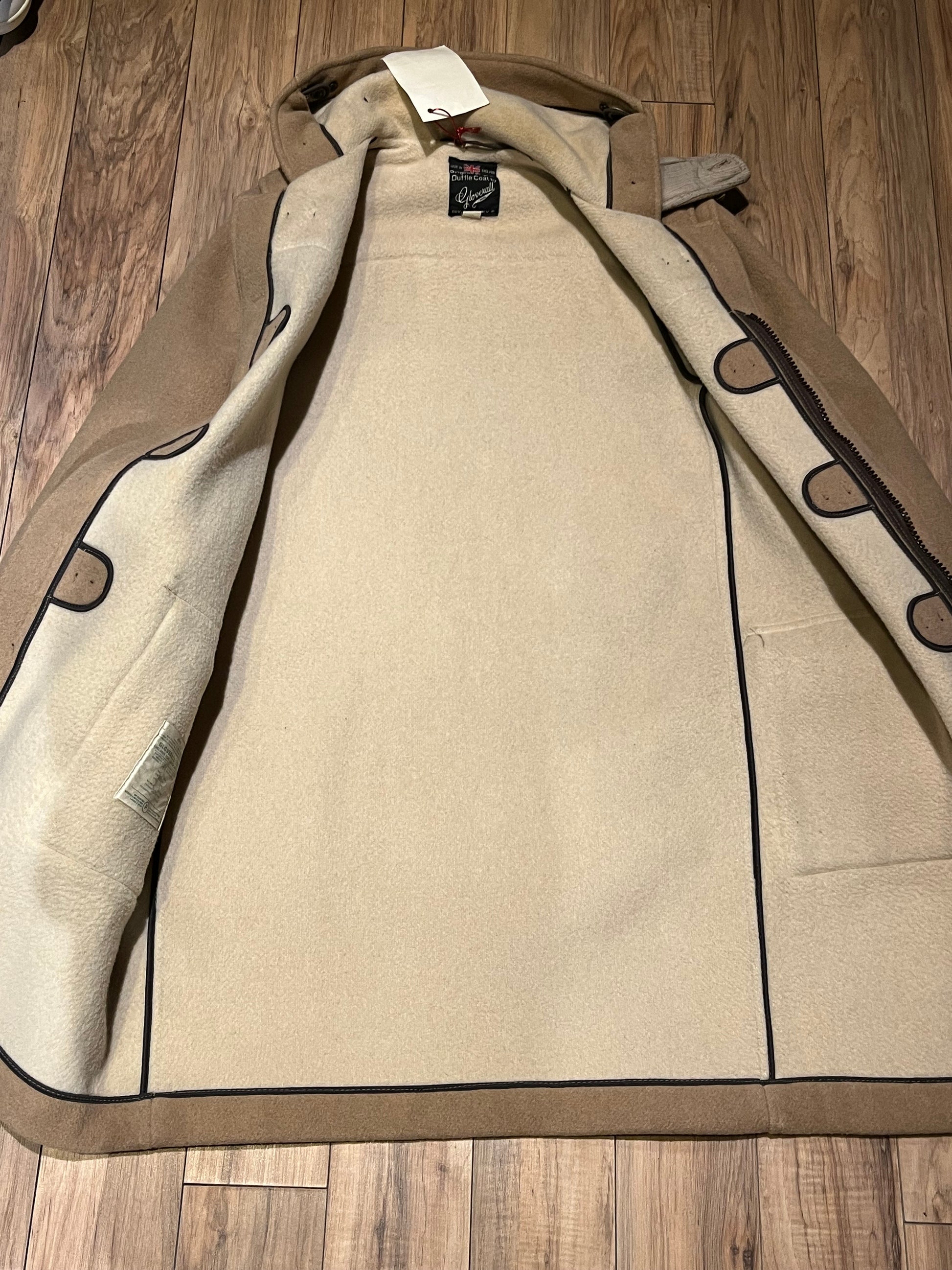 Vintage Gloverall tan duffle coat, with zipper and horn toggle closures, hood and two flap pockets.
80% wool/ 20% polyester
Made in England
Size 52