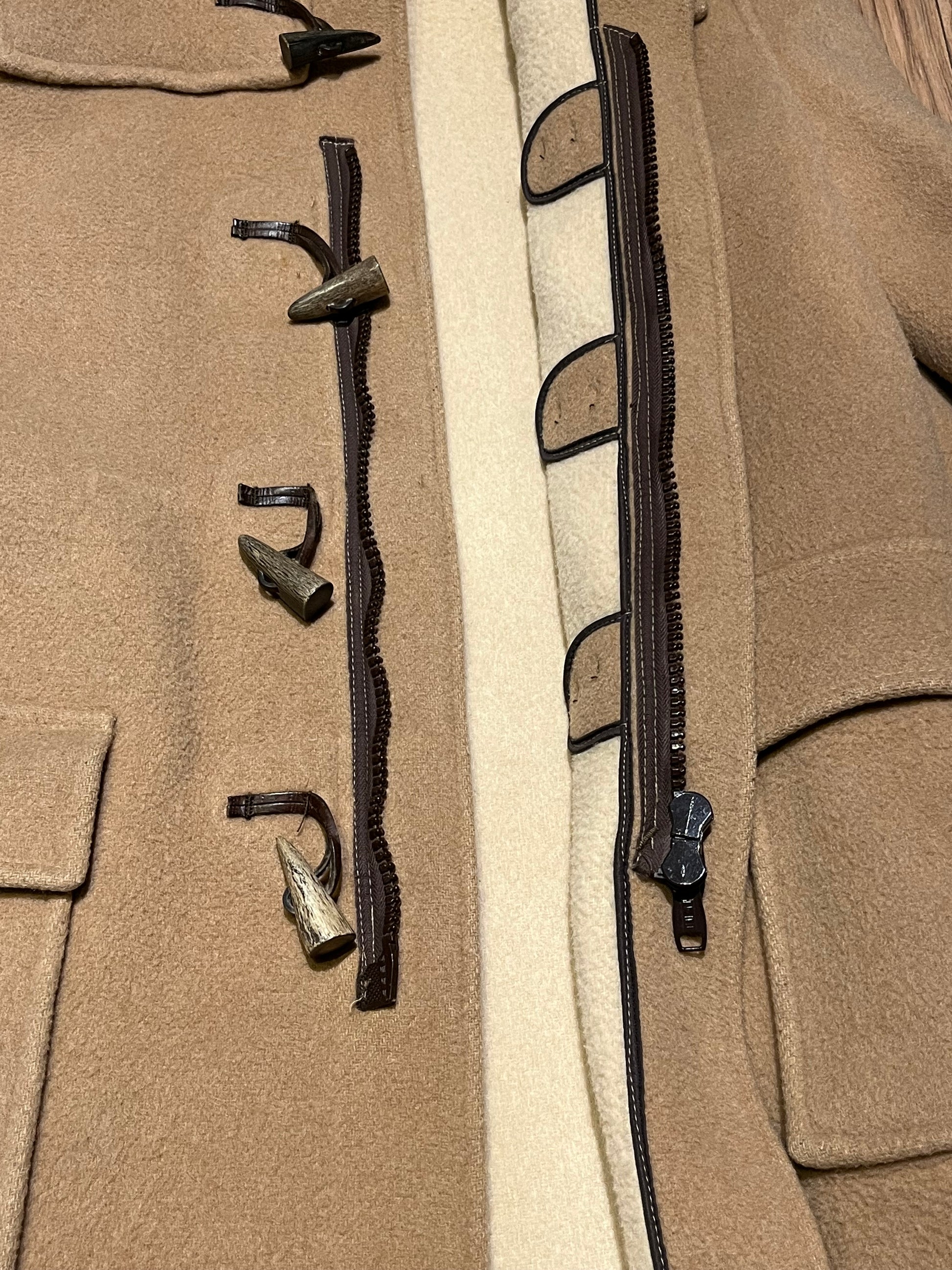 Vintage Gloverall tan duffle coat, with zipper and horn toggle closures, hood and two flap pockets.
80% wool/ 20% polyester
Made in England
Size 52