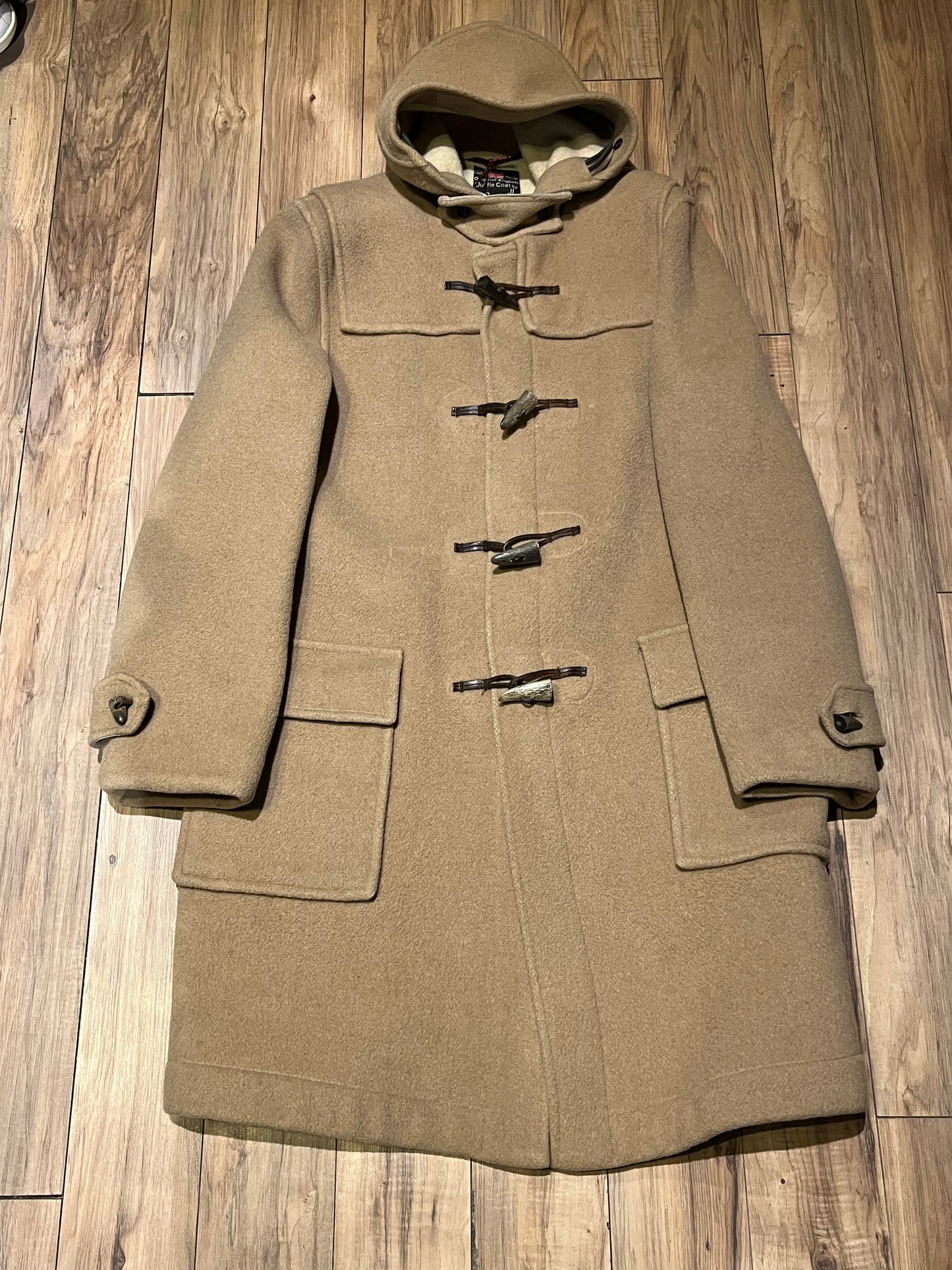Vintage Gloverall tan duffle coat, with zipper and horn toggle closures, hood and two flap pockets.
80% wool/ 20% polyester
Made in England
Size 52