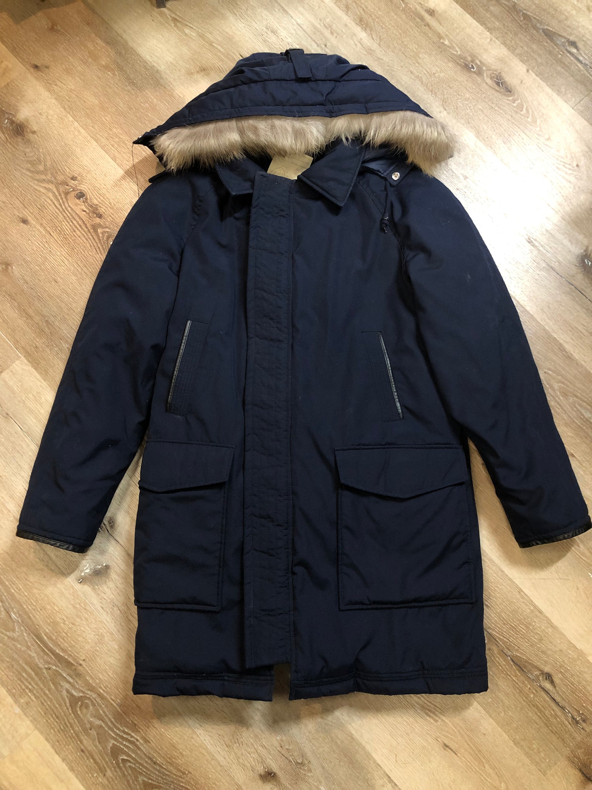 Kingspier Vintage - Vintage down filled cold weather parka in black with no labels.
This parka features a hood with coyote fur trim, quilted lining, storm cuffs, hand warmer pockets and flap pockets, zipper closure, polyester/ cotton shell with 60% down/ 40% waterfowl feather fill.
Made in Korea.
Size 42.