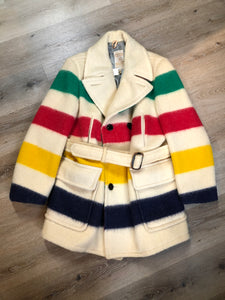 Kingspier Vintage - Genuine Hudson’s Bay Company point blanket coat in the iconic multistripe colours. The coat features flap pockets and hand warmer pockets, double breasted button closures and belt. Made in Canada. Men’s size 46.
