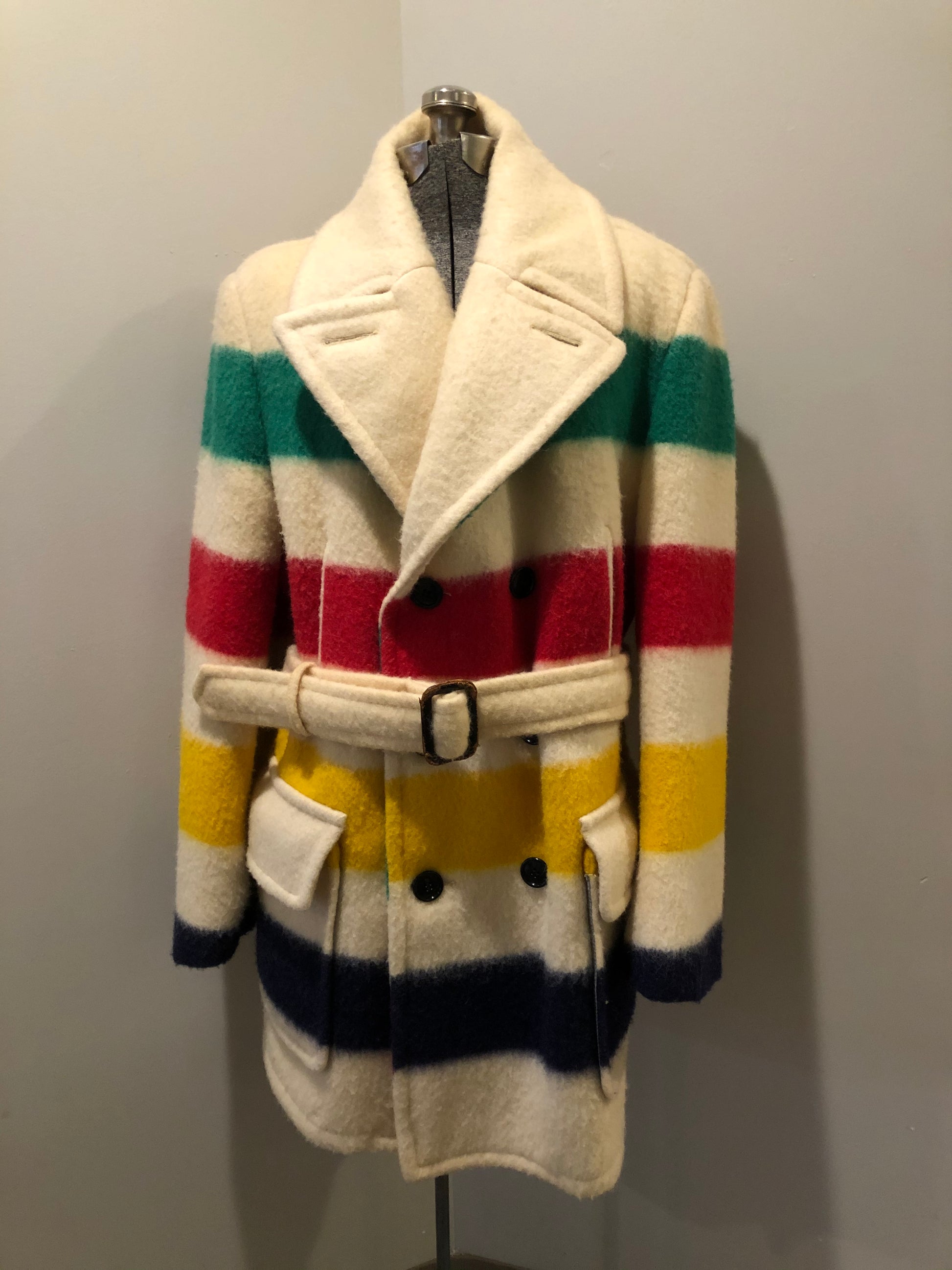Kingspier Vintage - Genuine Hudson’s Bay Company point blanket coat in the iconic multistripe colours. The coat features flap pockets and hand warmer pockets, double breasted button closures and belt. Made in Canada. Men’s size 46.