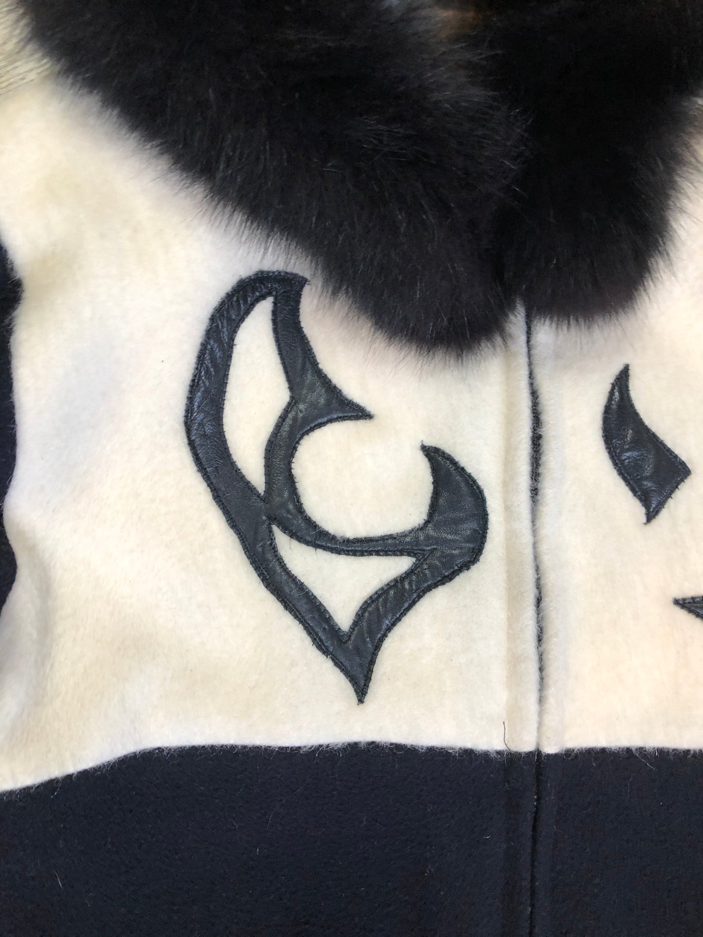 Kingspier Vintage - Linda Lundstrom full length black and white wool coat with fur hood, soft leather applique on the chest and back, zipper closures and a black satin like lining. Made in Canada.