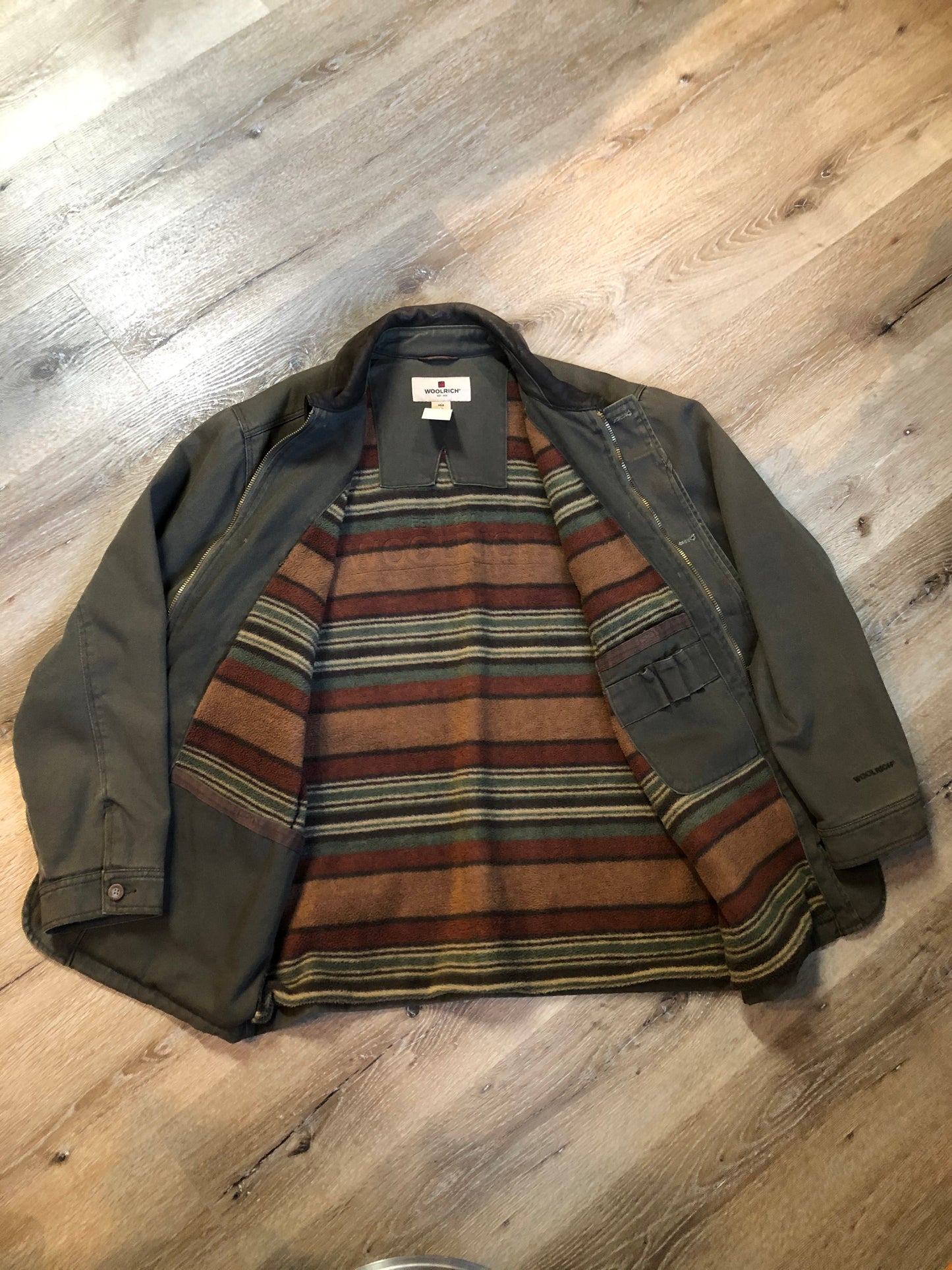 Kingspier Vintage - Woolrich olive green chore jacket features suede collar, flap pockets, hand warmer pockets, zipper and button closures, inside autumn colour striped fleece lining and inside pocket with pencil/ small tool holders. Men’s large.