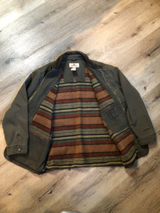 Kingspier Vintage - Woolrich olive green chore jacket features suede collar, flap pockets, hand warmer pockets, zipper and button closures, inside autumn colour striped fleece lining and inside pocket with pencil/ small tool holders. Men’s large.
