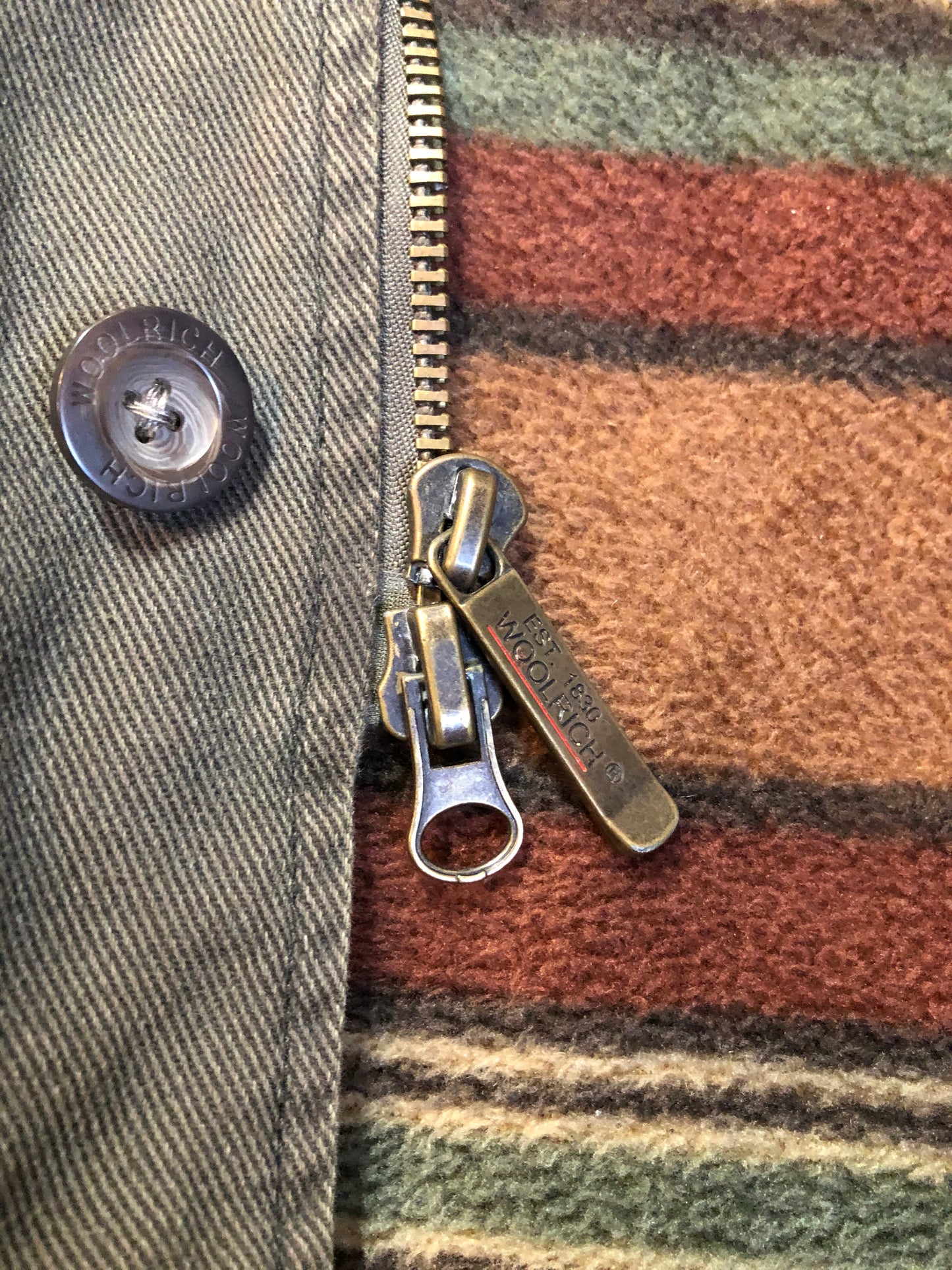 Kingspier Vintage - Woolrich olive green chore jacket features suede collar, flap pockets, hand warmer pockets, zipper and button closures, inside autumn colour striped fleece lining and inside pocket with pencil/ small tool holders. Men’s large.