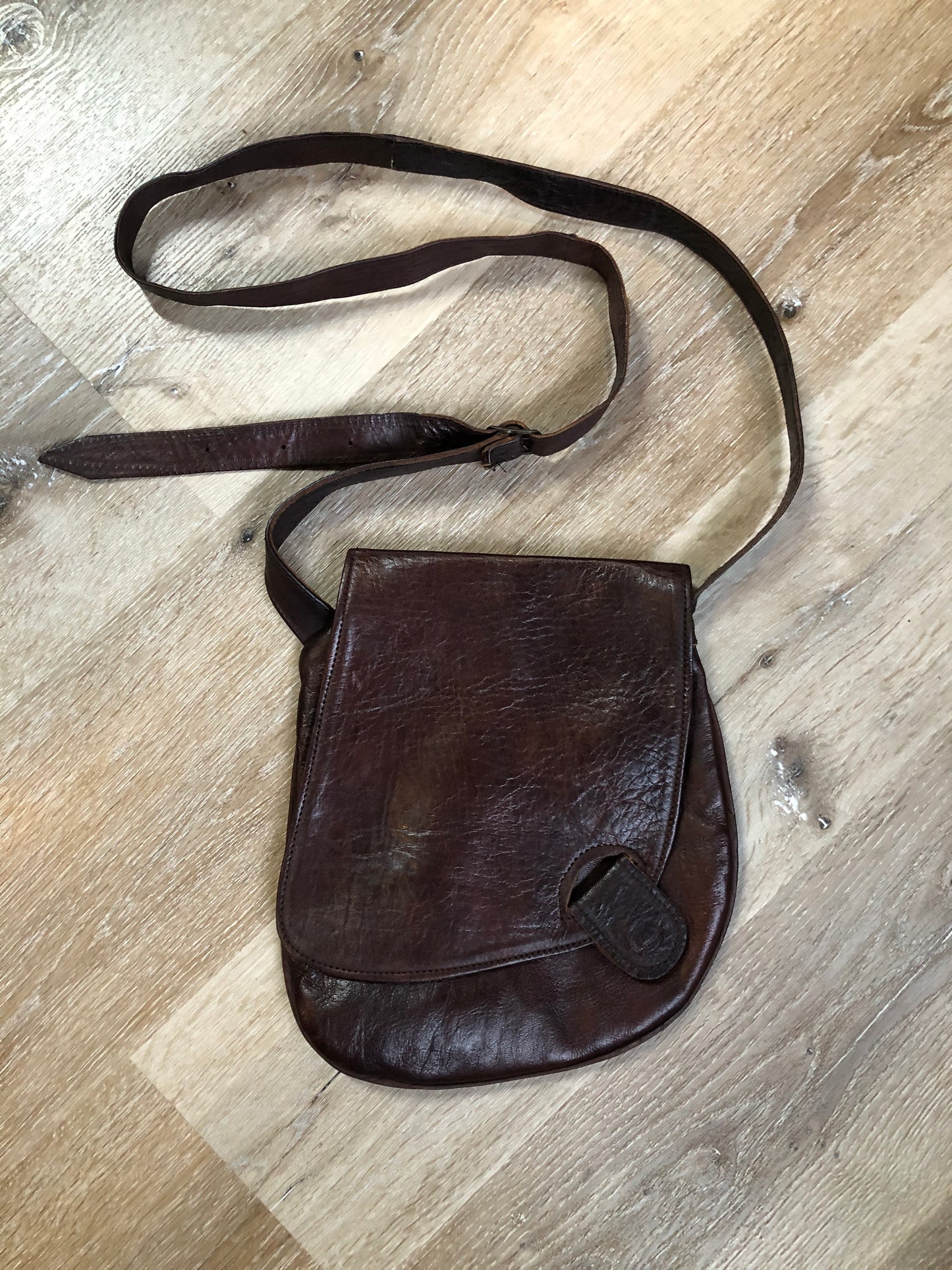 Kingspier Vintage - Asymmetrical brown leather crossbody bag with front magnetic snap closure, one large compartment with small zip pocket inside
Length - 9.5”
Width - ..5”
Height - 10”
Strap - 49” - 57”
This purse is in excellent condition.
