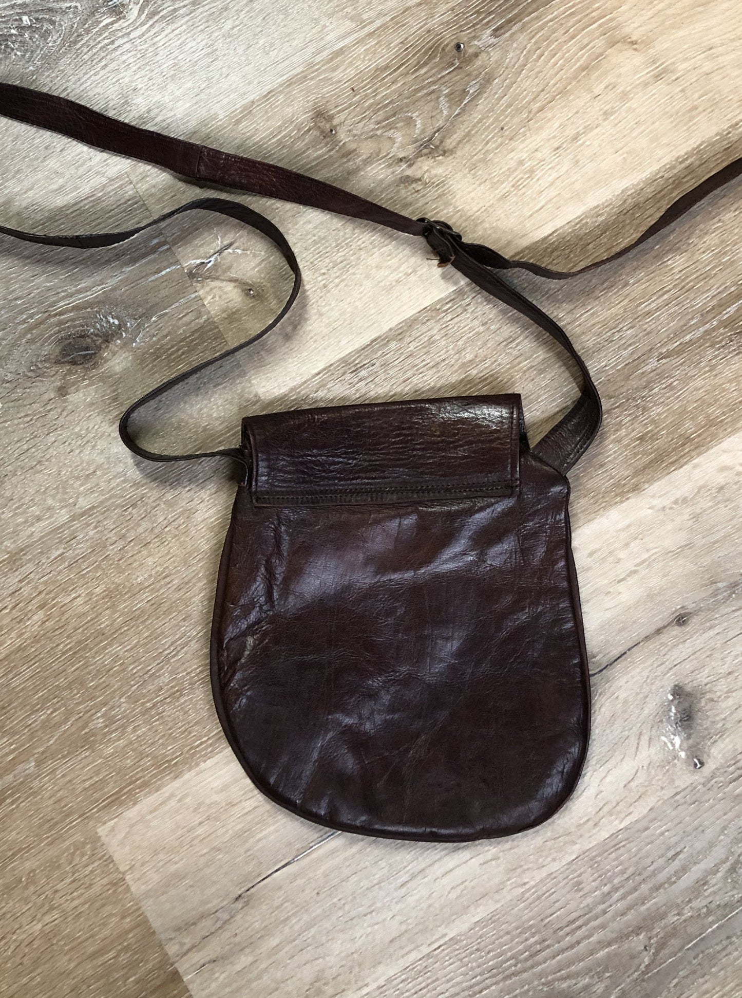 Kingspier Vintage - Asymmetrical brown leather crossbody bag with front magnetic snap closure, one large compartment with small zip pocket inside
Length - 9.5”
Width - ..5”
Height - 10”
Strap - 49” - 57”
This purse is in excellent condition.