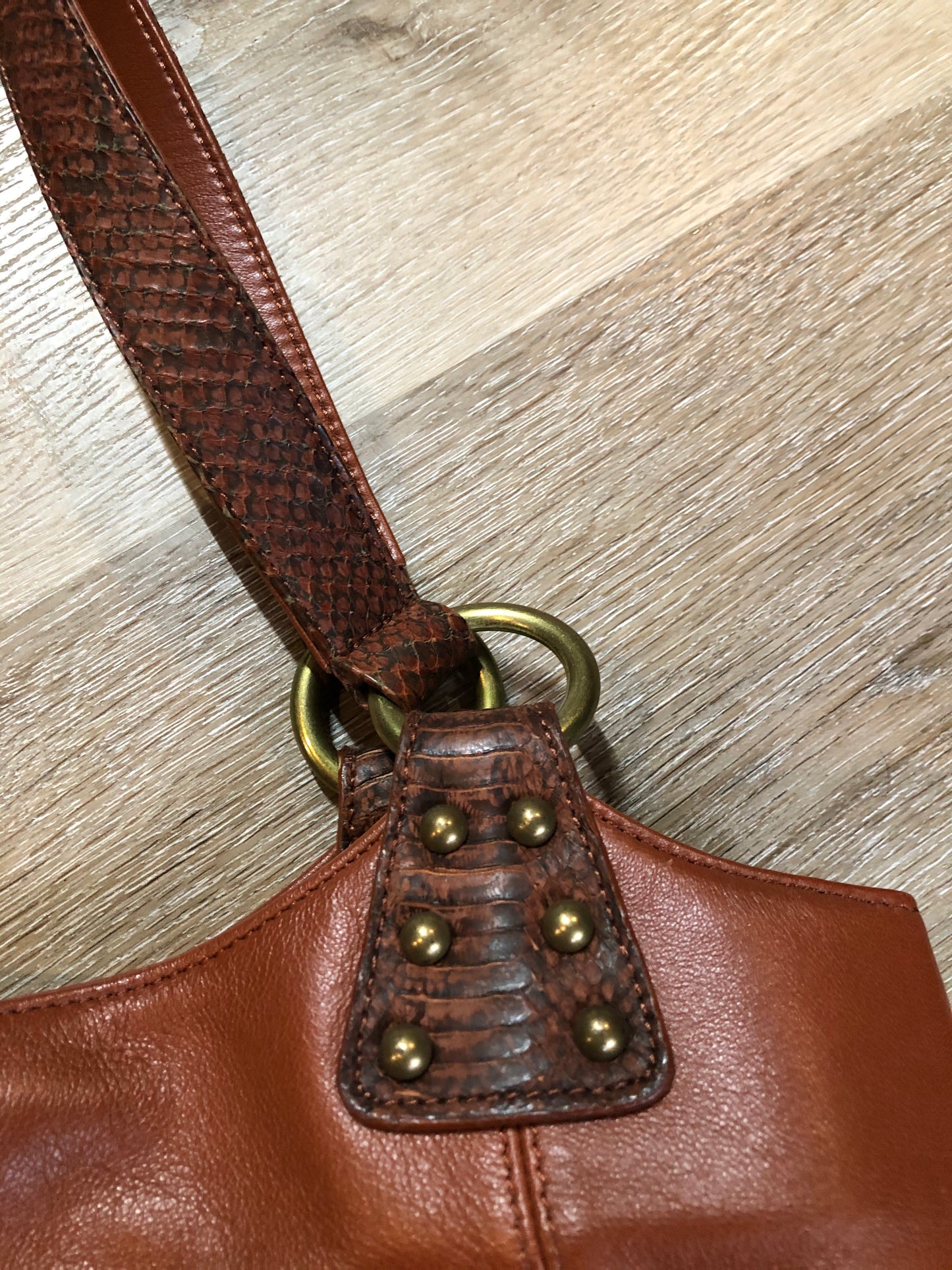 Kingspier Vintage - Chi sienna brown lambskin handbag with snakeskin trim, three inside compartments, middle compartment has phone holder, pen holders and money clip
Length - 13”
Width - .7”
Height - 9.5”
Strap - 19”
This purse is in excellent condition.