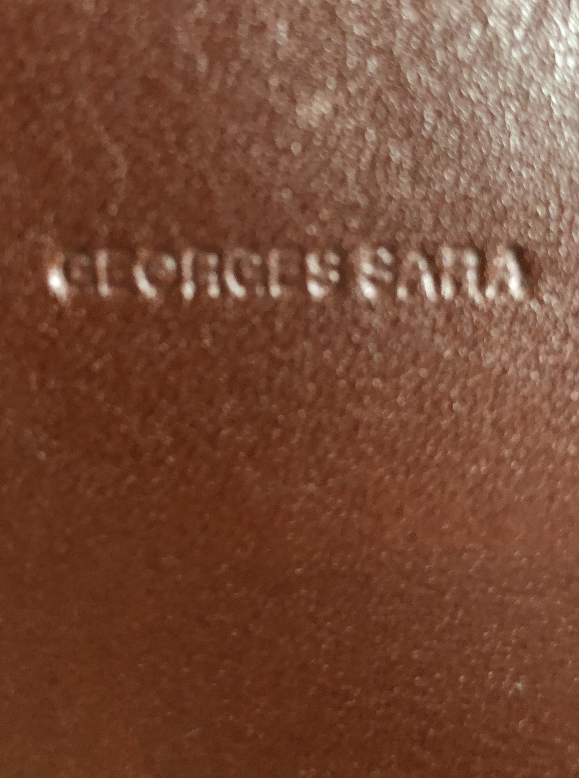 Kingspier Vintage - Georges Sara brown leather handbag with unique brass hardware, zipper top closure with three compartments inside. 
Length - 11.5”
Width - .5”
Height - 9”
Strap - 30”
This purse is in excellent condition.