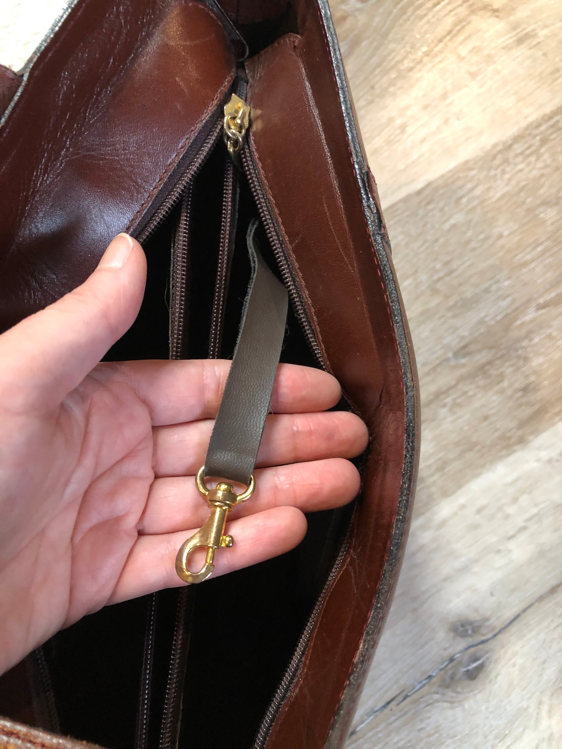 Kingspier Vintage - Georges Sara brown leather handbag with unique brass hardware, zipper top closure with three compartments inside. 
Length - 11.5”
Width - .5”
Height - 9”
Strap - 30”
This purse is in excellent condition.