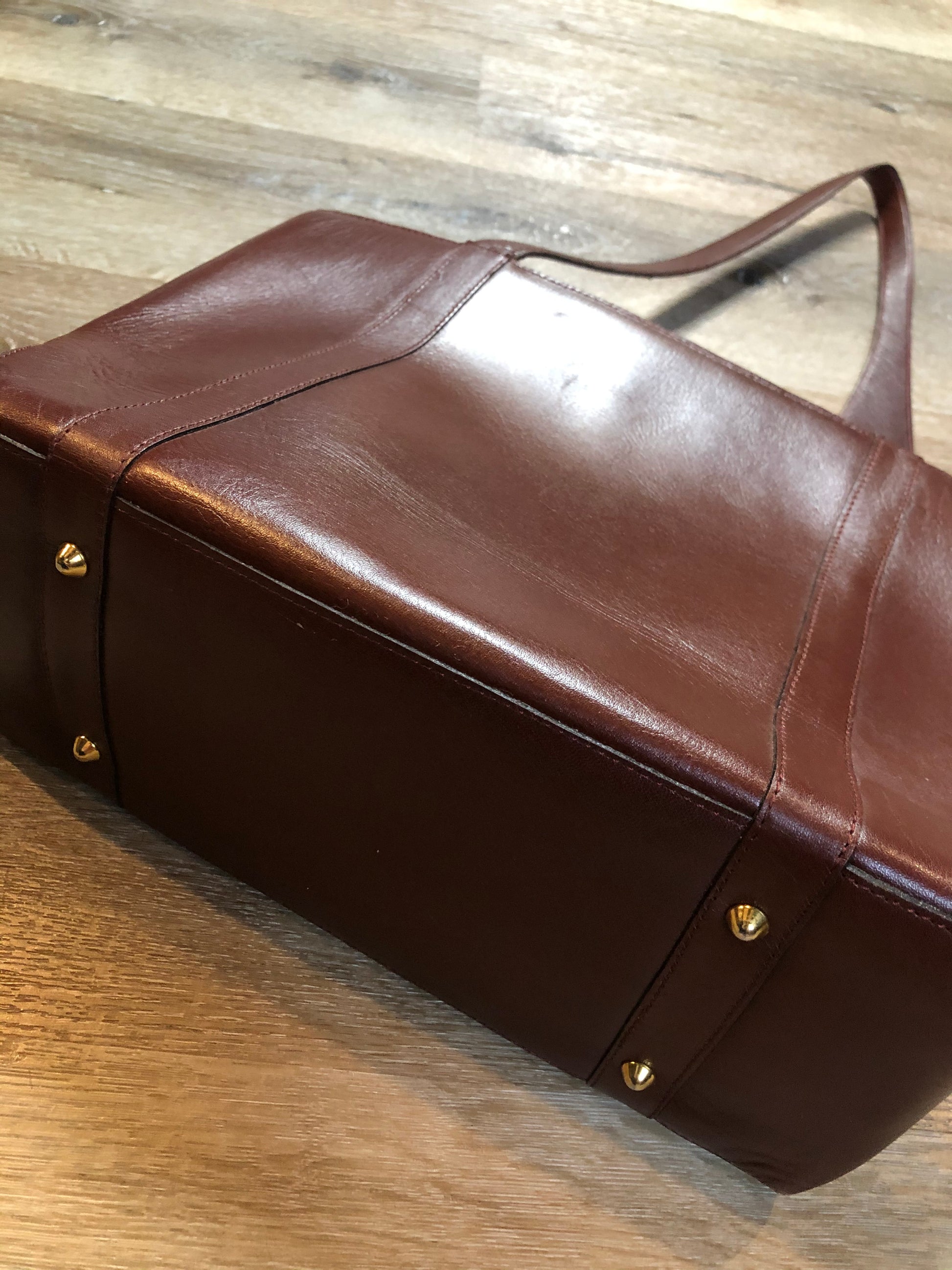 Kingspier Vintage - Georges Sara brown leather handbag with unique brass hardware, zipper top closure with three compartments inside. 
Length - 11.5”
Width - .5”
Height - 9”
Strap - 30”
This purse is in excellent condition.