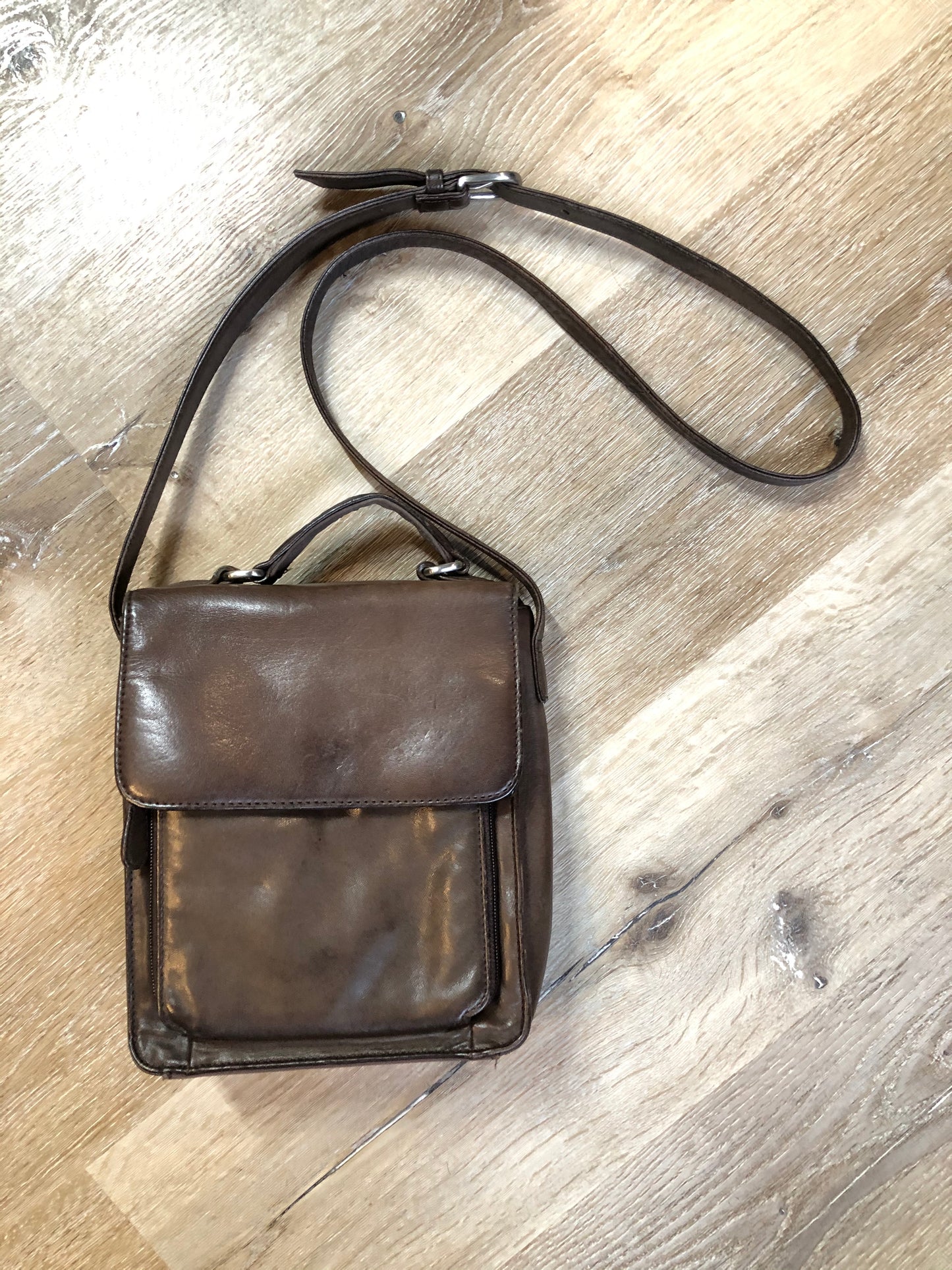 Kingspier Vintage - Brown leather crossbody bag with adjustable strap, top handle,two compartments, front compartment zips open with card holders.
Length - 7”
Width - .3”
Height - 8”
Strap - 44”-47”
This purse is in great condition with some minor wear.